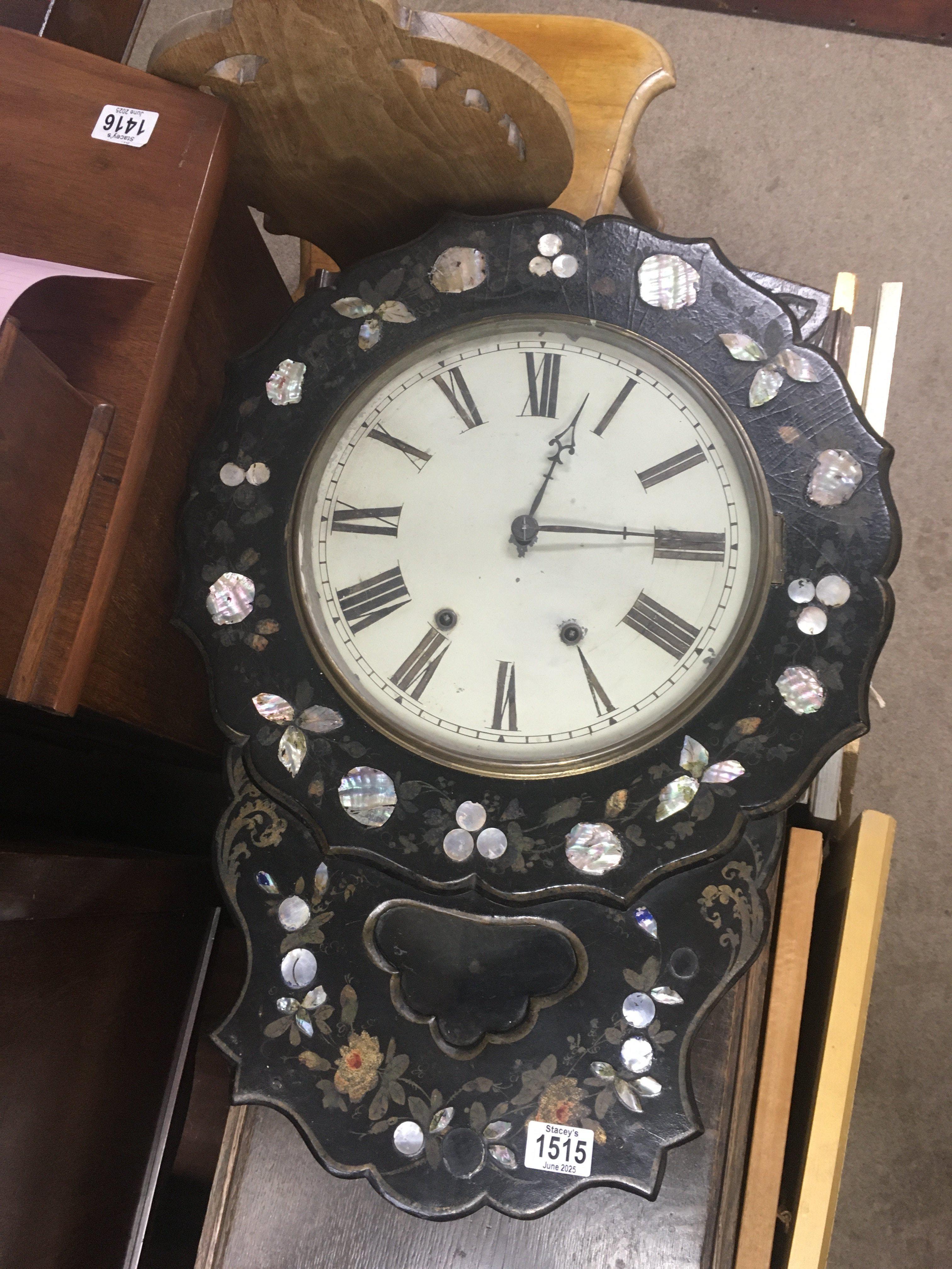 A Victorian wall clock the mother of pearl case inset with a circular dial With Roman numerals.