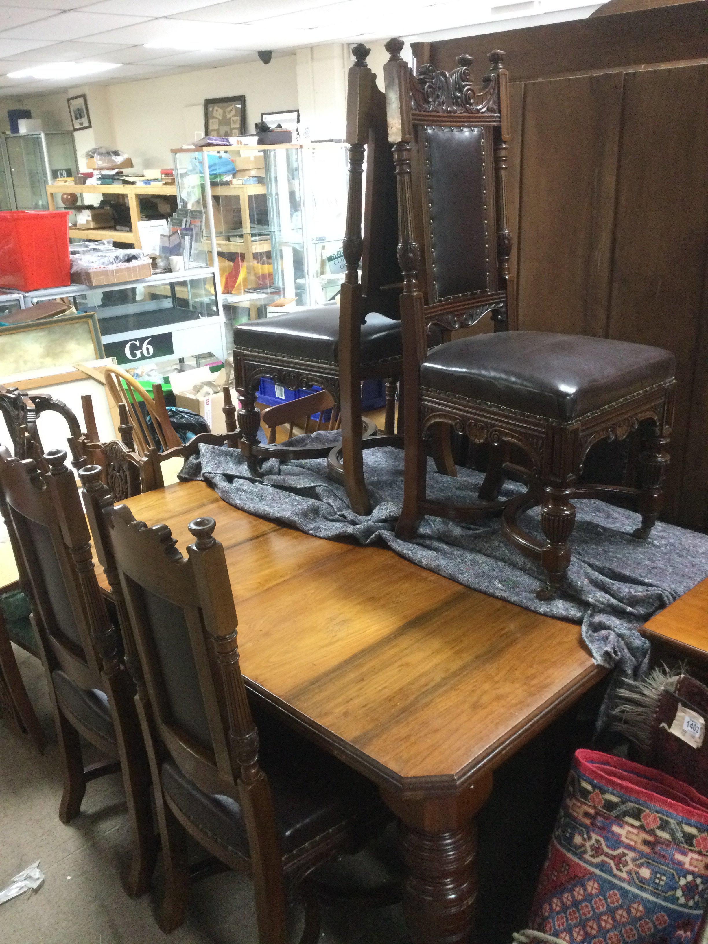 An Edwardian dining table with six quality carved walnut chairs (7). Shipping category D.