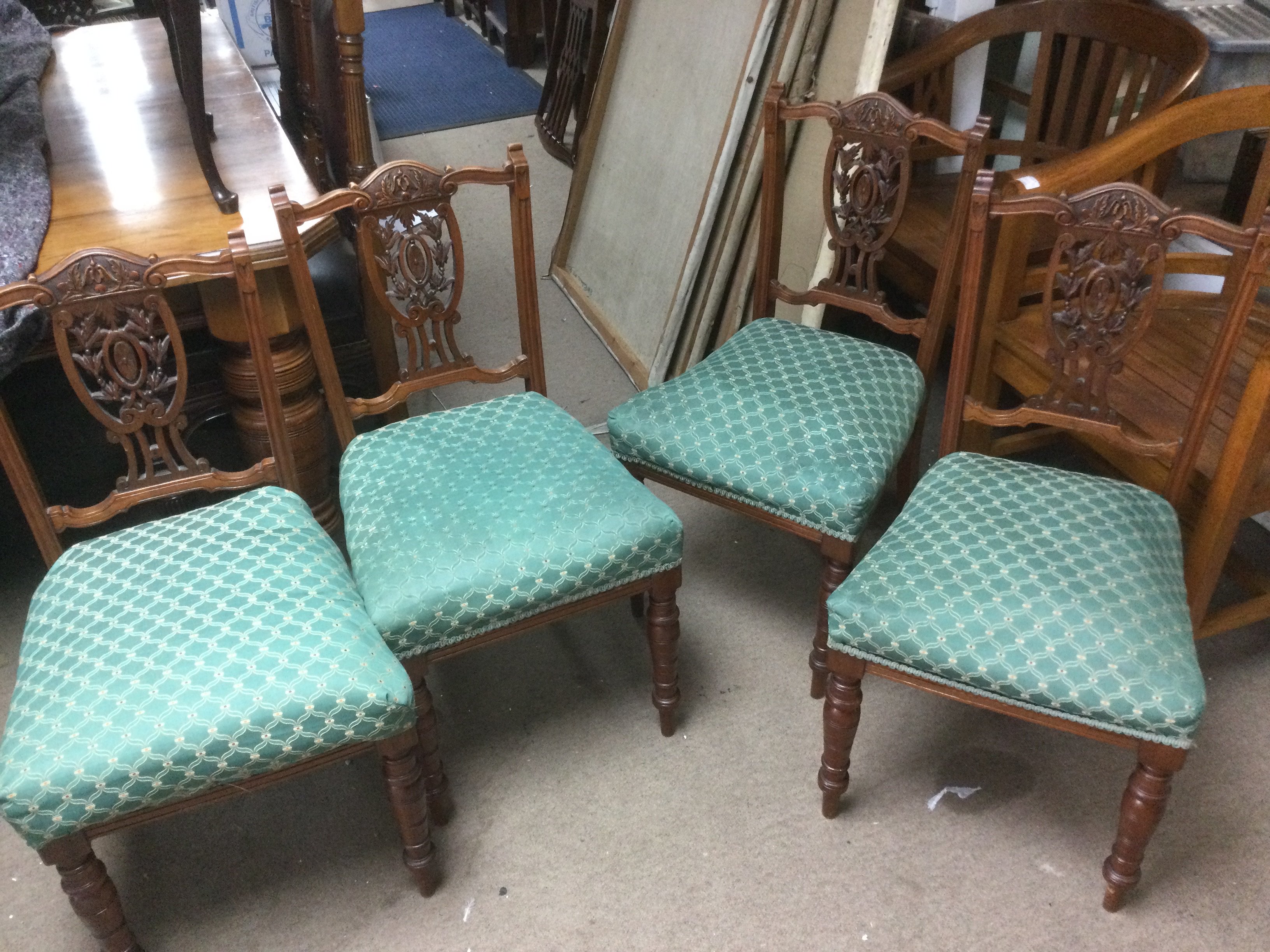 A set of four Edwardian chairs with carved backs. Shipping category D.