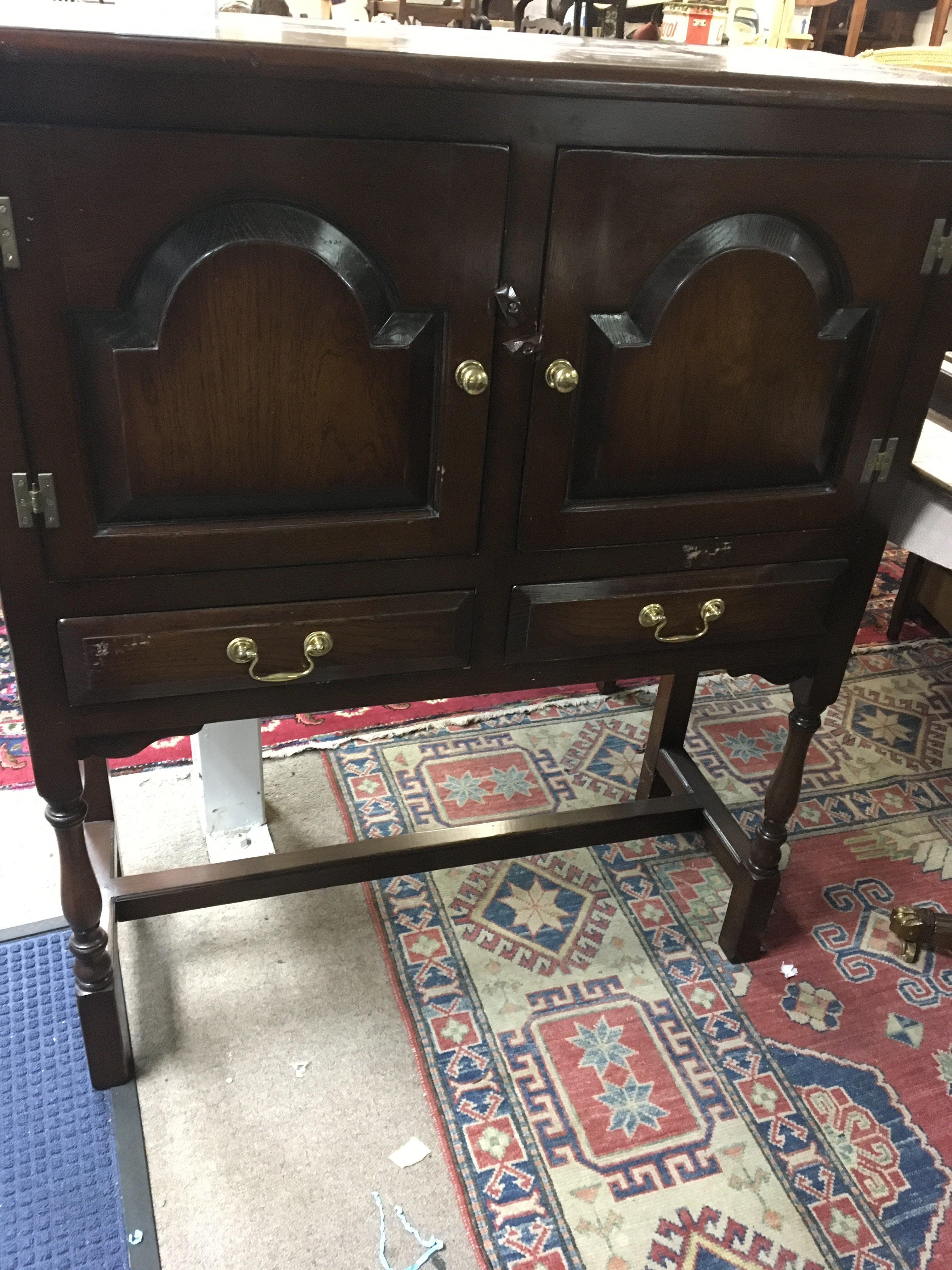 A oak cupboard the two drawers above two single drawers on turned legs .
