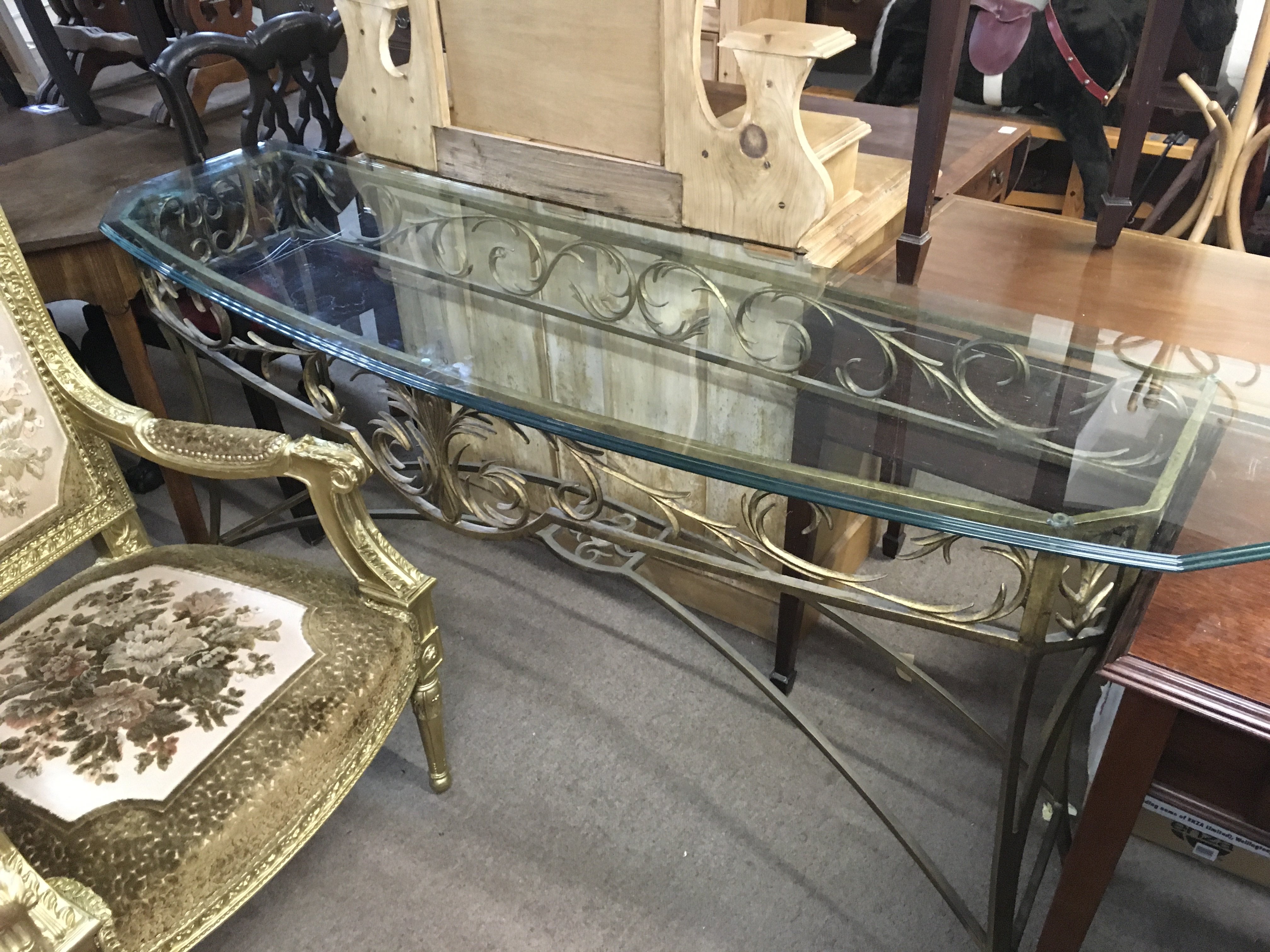 A modern glass with gilt wrought iron frame, 168cm wide 82cm tall