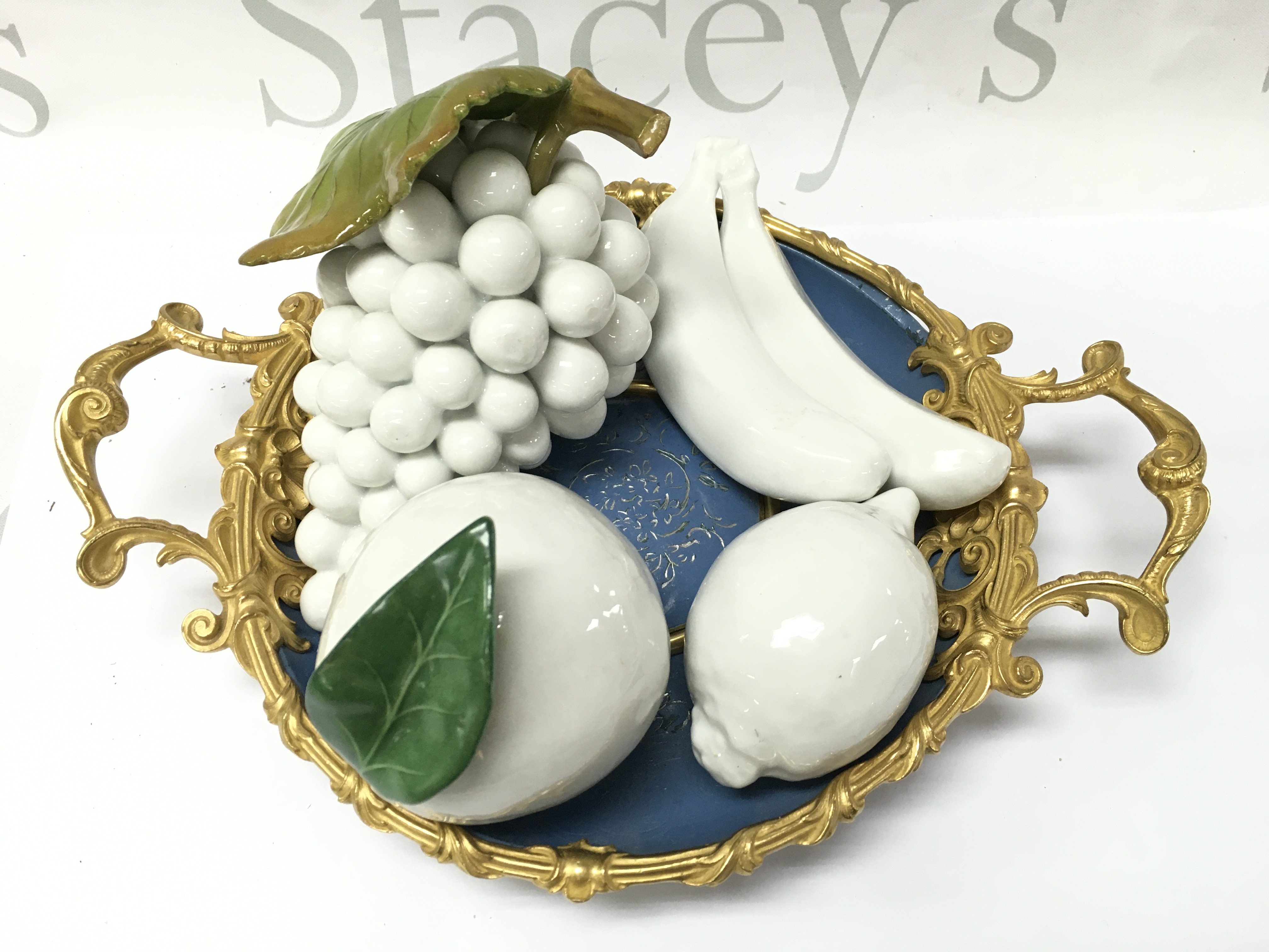 White porcelain fruit on a blue and gilt dish. This lot cannot be posted