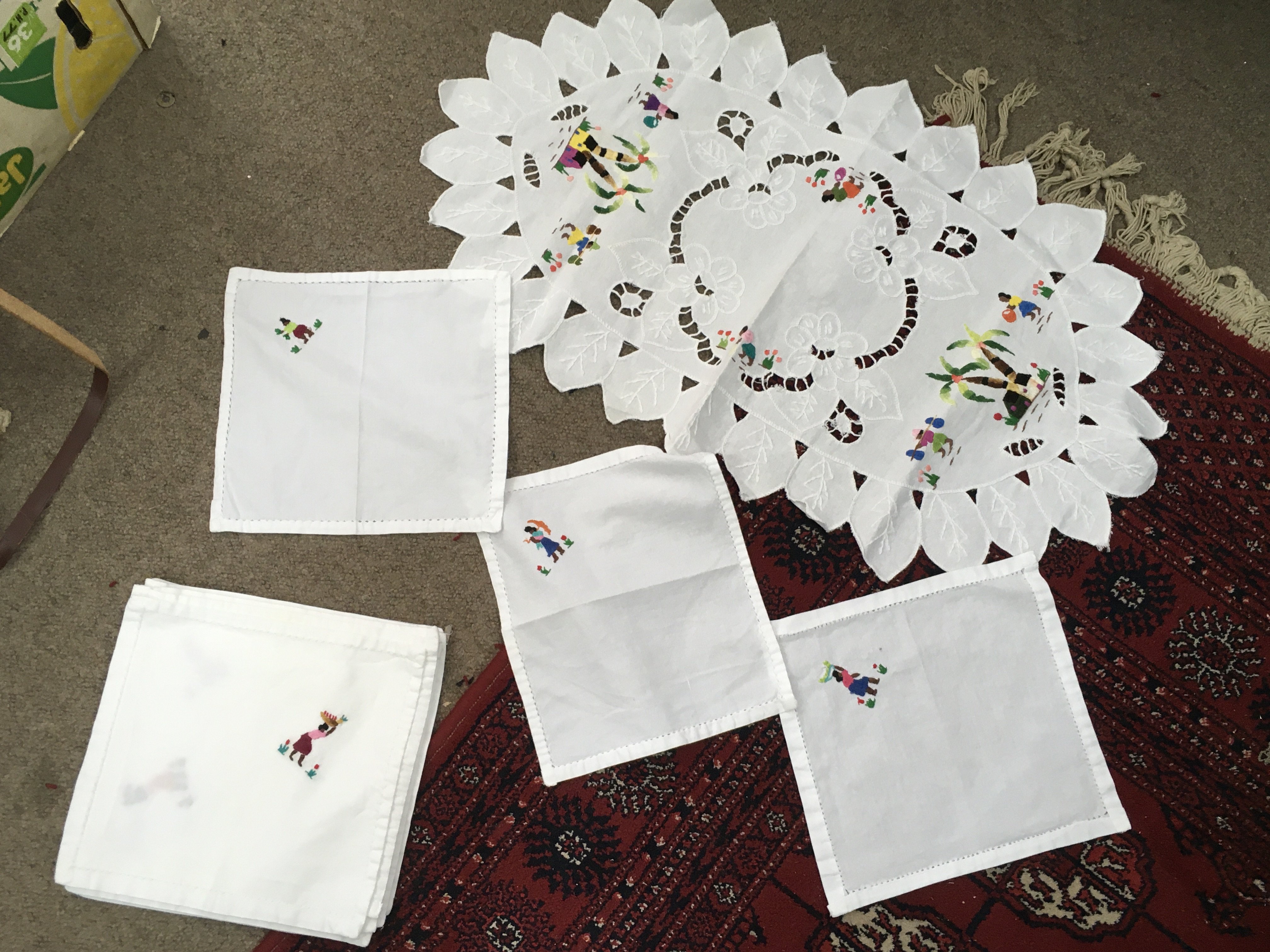 A collection of embroidered linen and lace tablecloths from Mauritius, 12 seater with matching napkins, centrepiece and additional linen. Postage category B- NO RESERVE