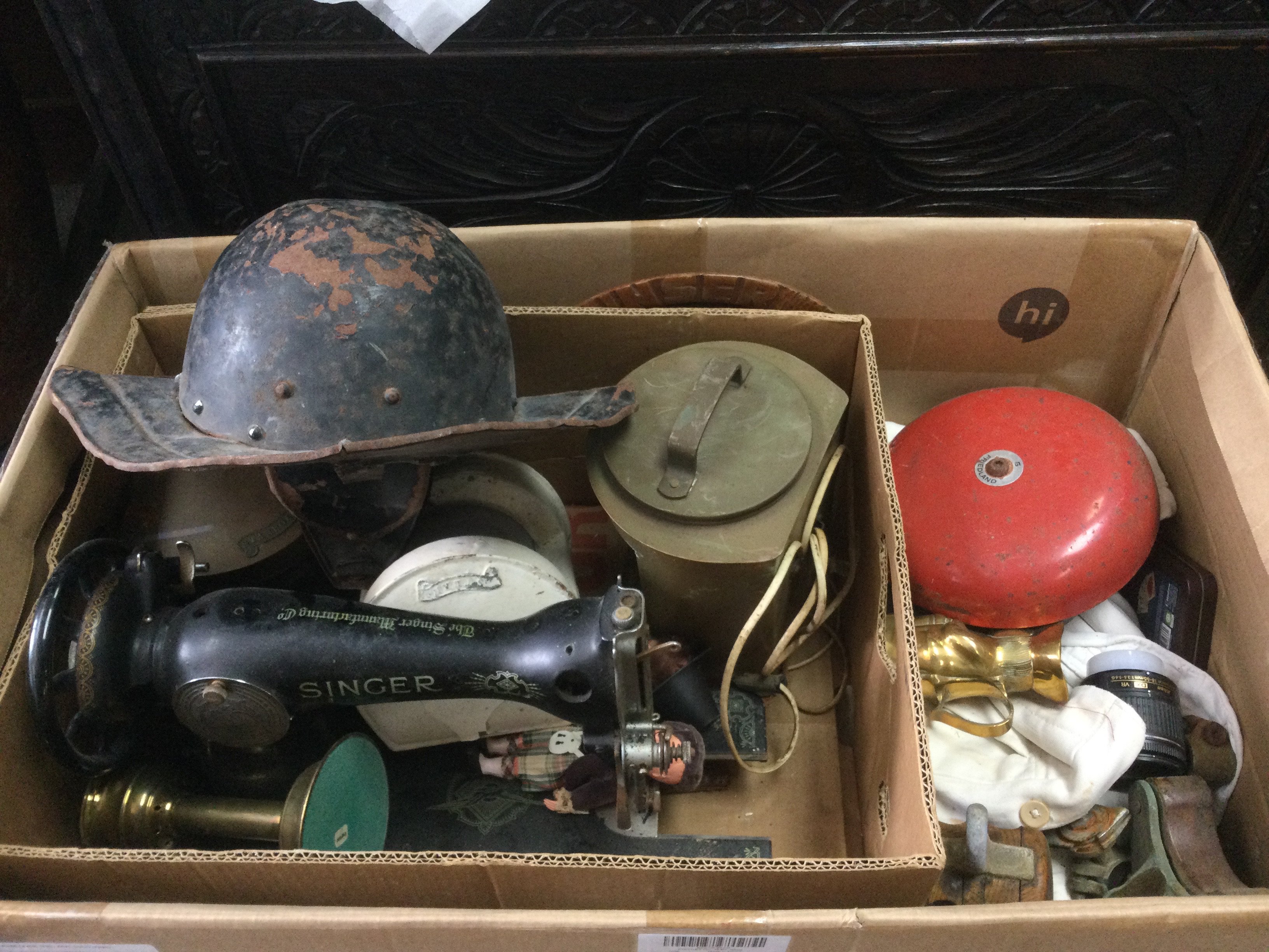 A large box of oddments including a Cromwellian Civil War style helmet, a Singer sewing machine, ship lights etc. Shipping category D