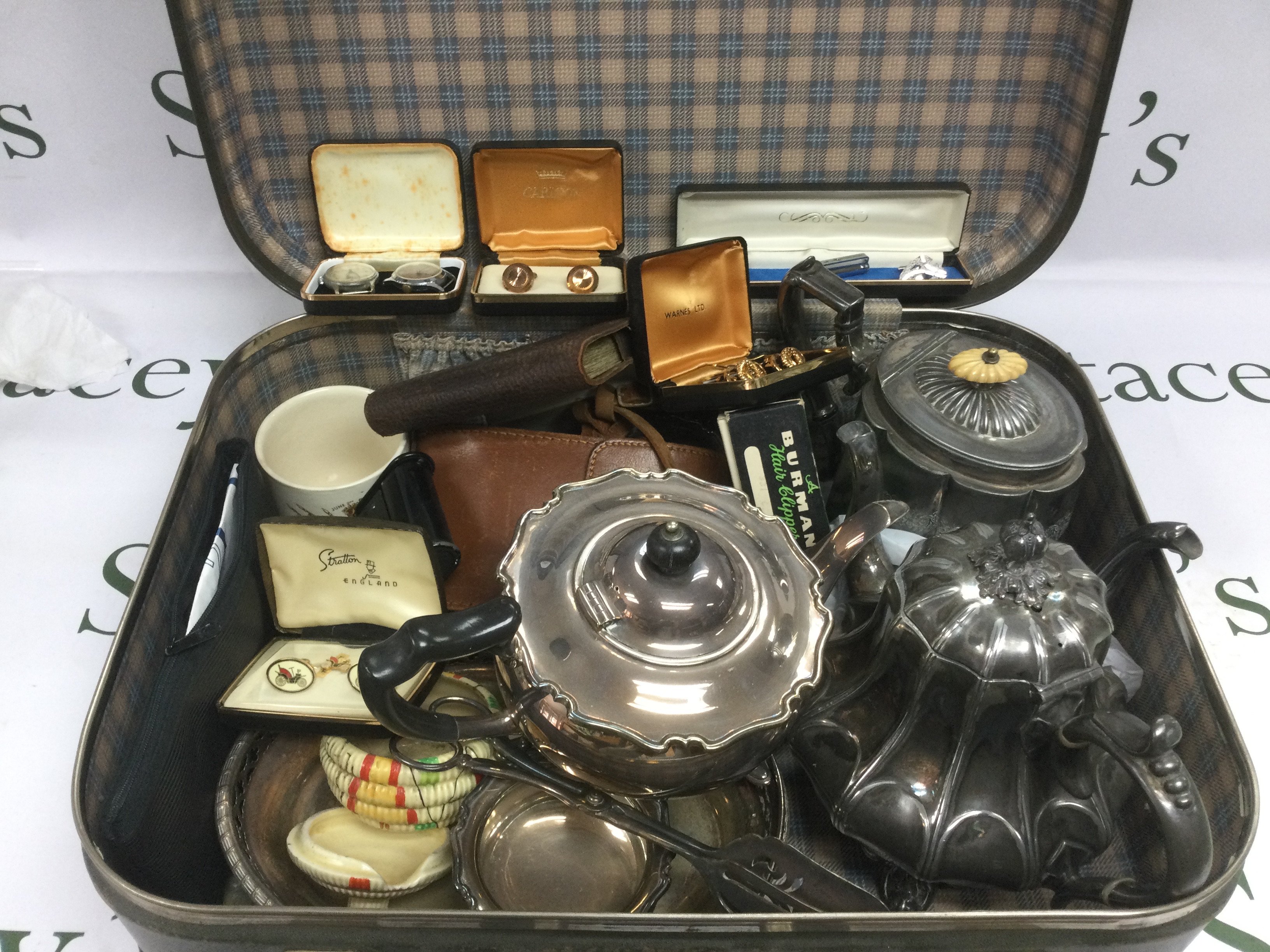 A suitcase of oddments comprising silver plated teapots, cufflinks etc. Shipping category D.