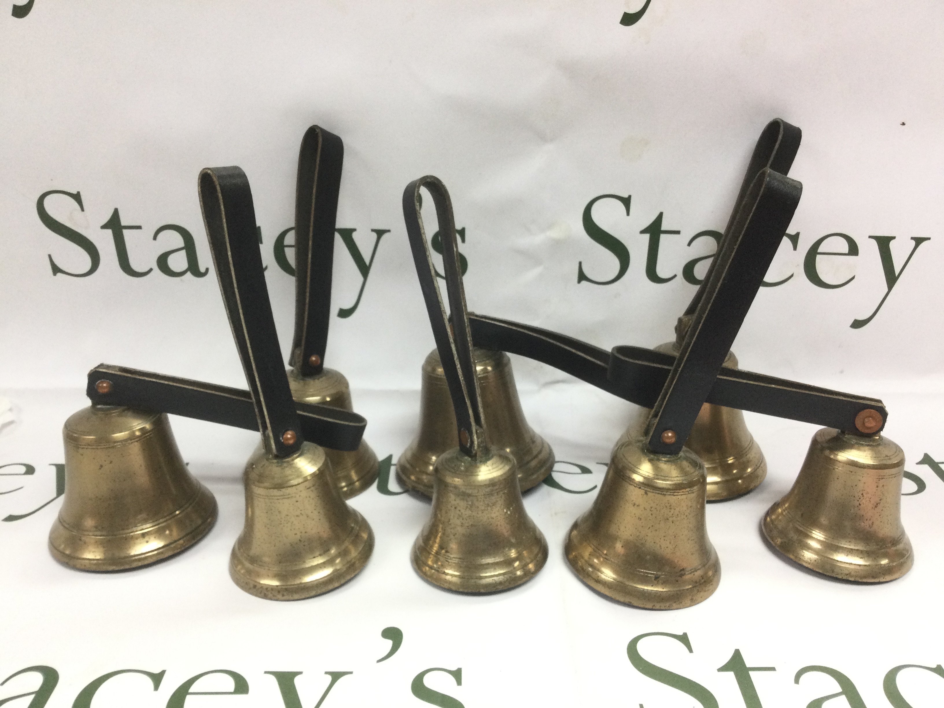 A collection of brass hand bells. Shipping category D.