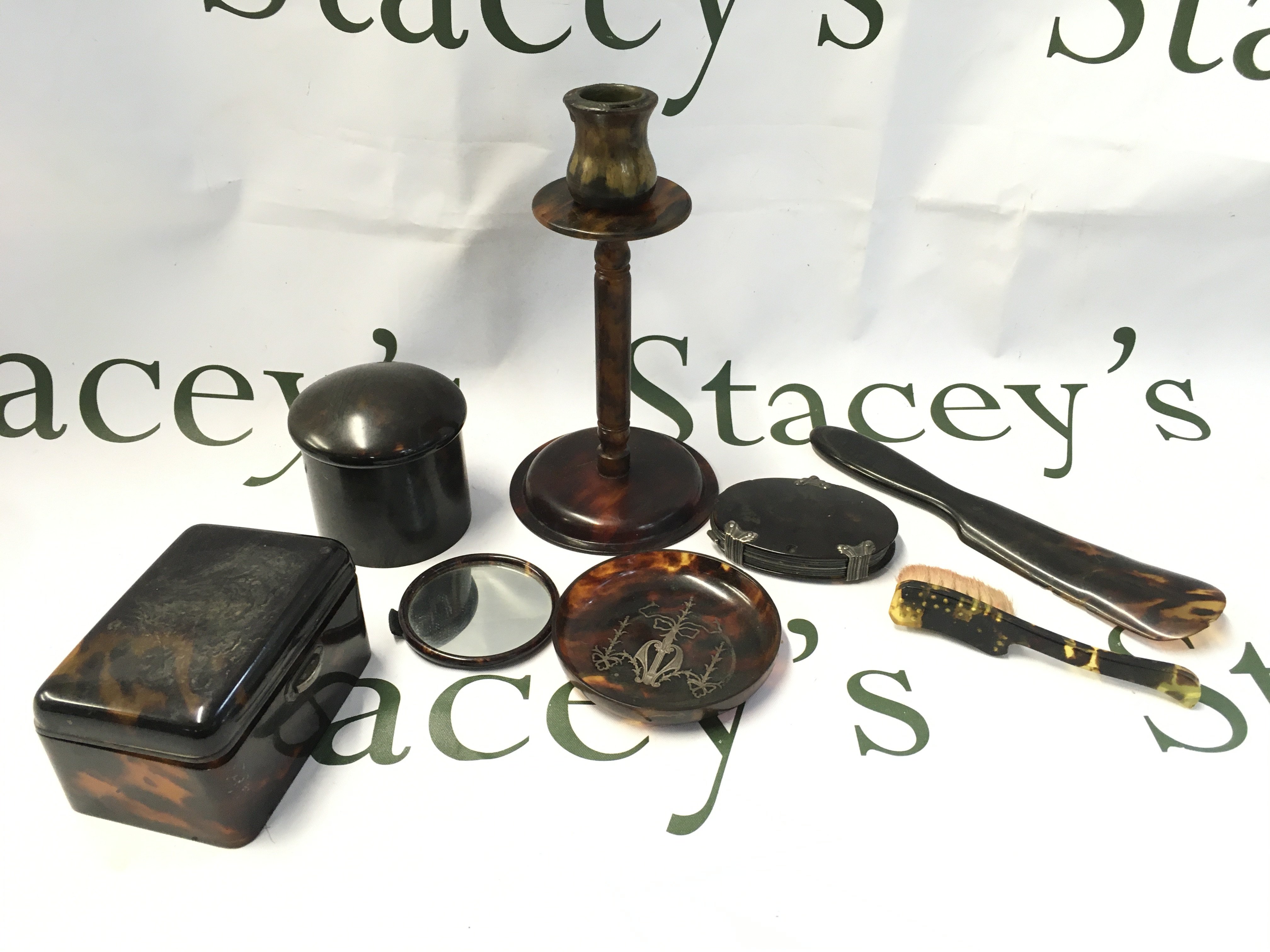 A collection of tortoiseshell items including candlestick , containers , mirror , dish etc. postage cat B