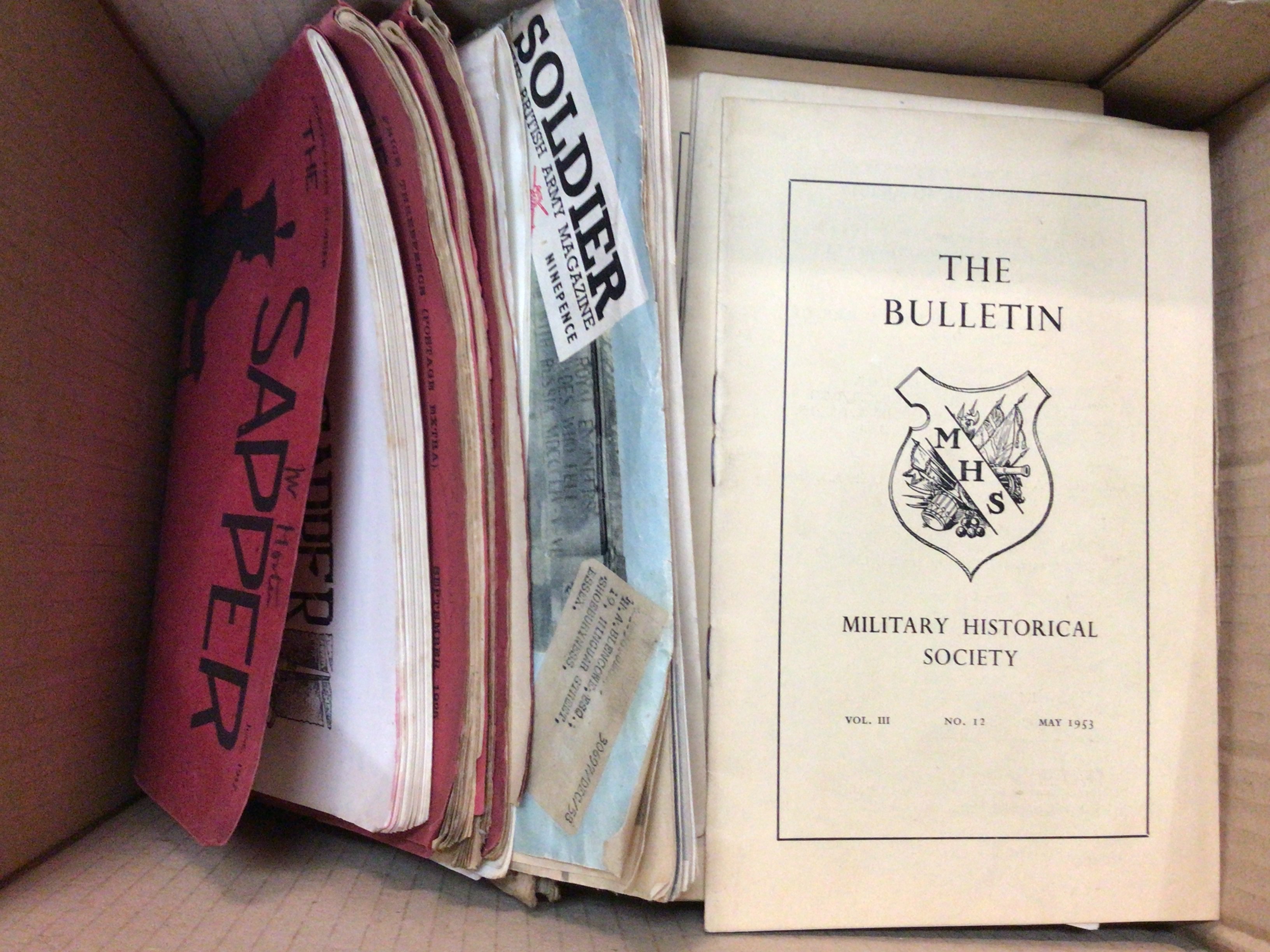 A box containing a collection of magazines including Military interest