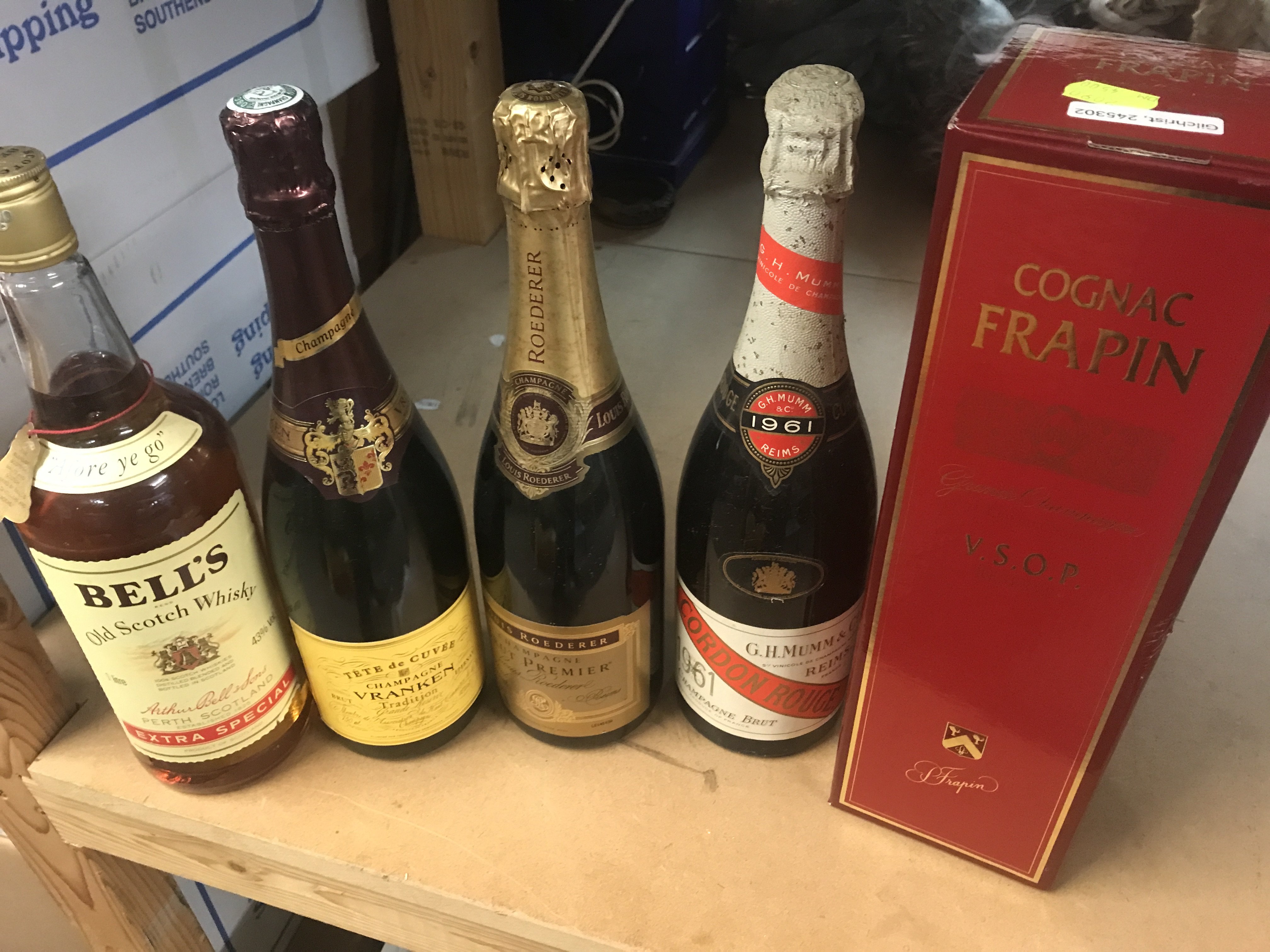 A box containing wines and sprites including cognac and bells whisky .