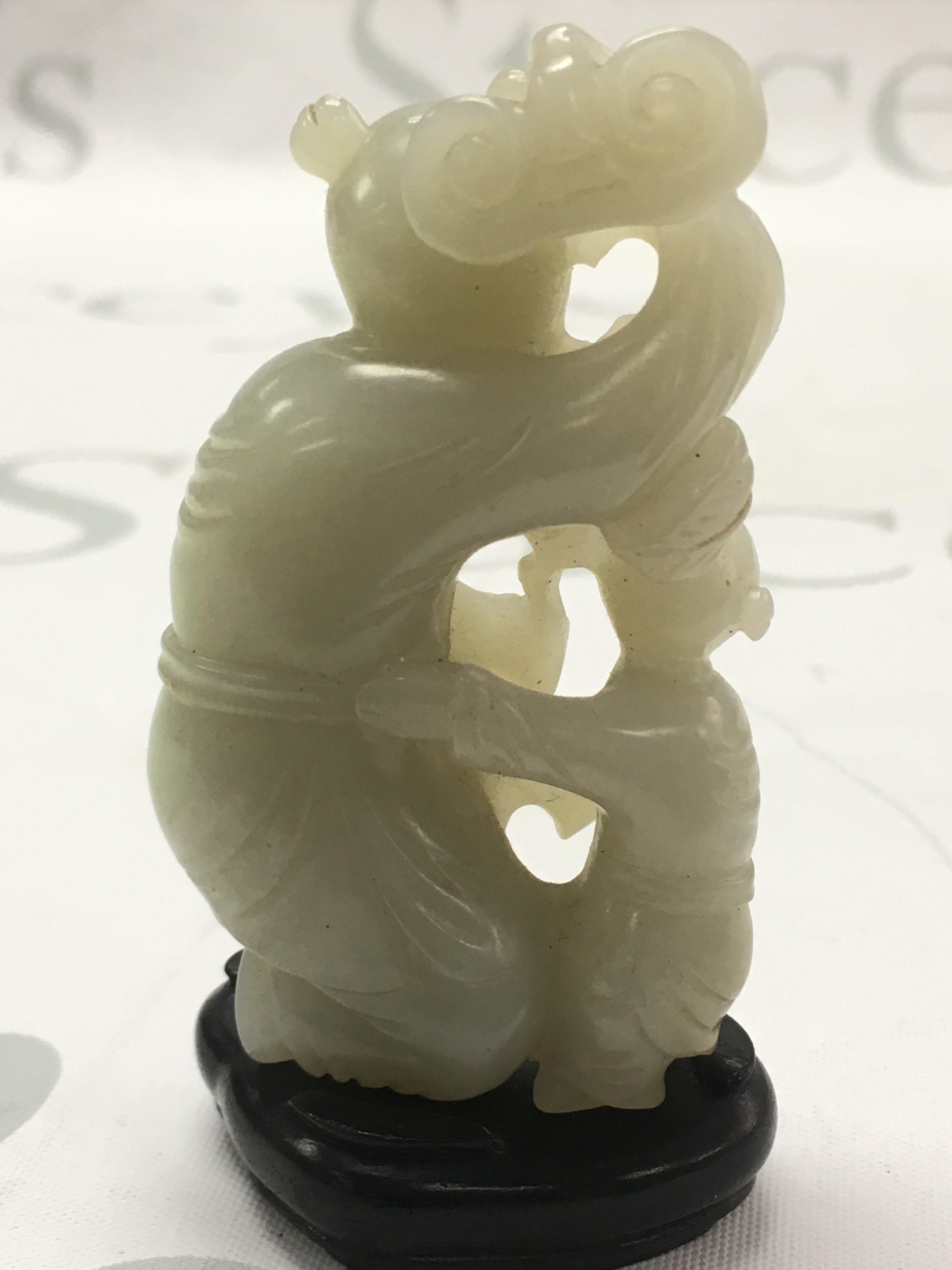 A Chinese jade figure group with stand, figure approximately 8cm tall. No obvious damage or restoration.Postage category A