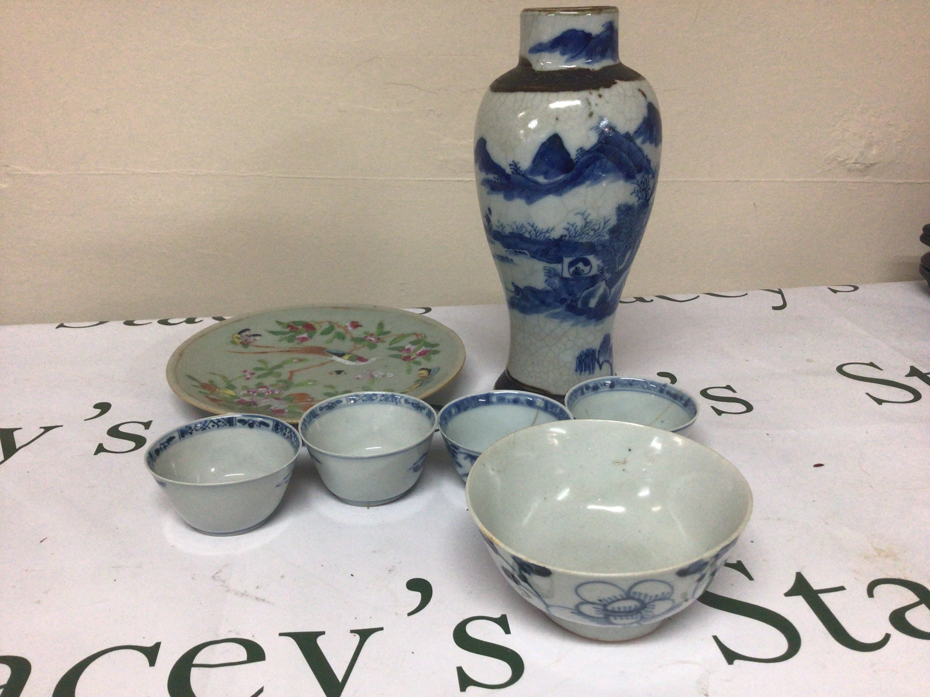 A collection of Chinese export porcelain late 18th century blue and white tea bowls a crackle ware vase celadon plate and other Chinese ceramics. Some damage.
