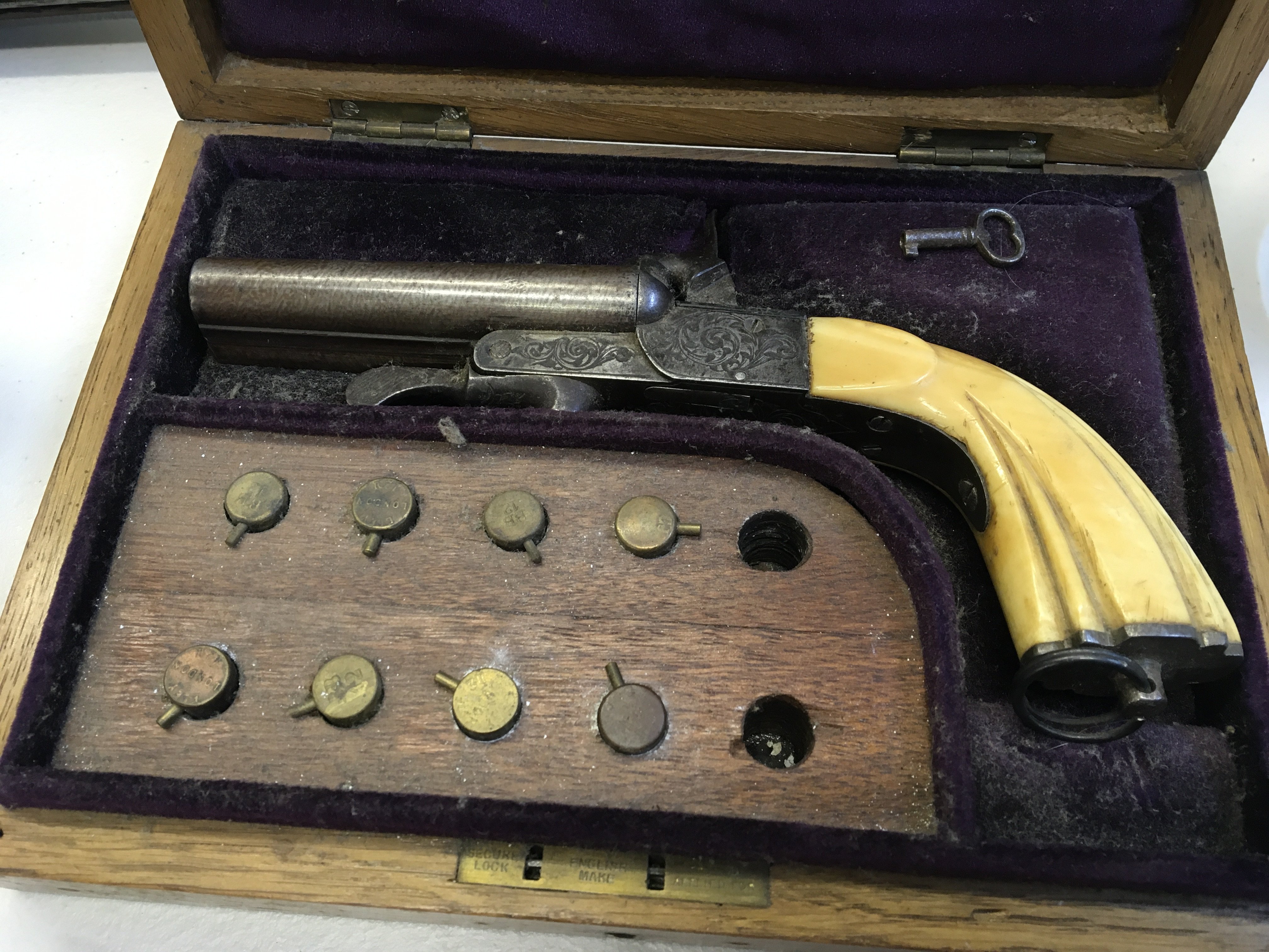 A Nice Example of a 19th Century Continental pin fire double barrel pistol with engraved action retractable triggers under leaver sliding opener for loading barrels in a fitted case with pin fire cartridges action working.