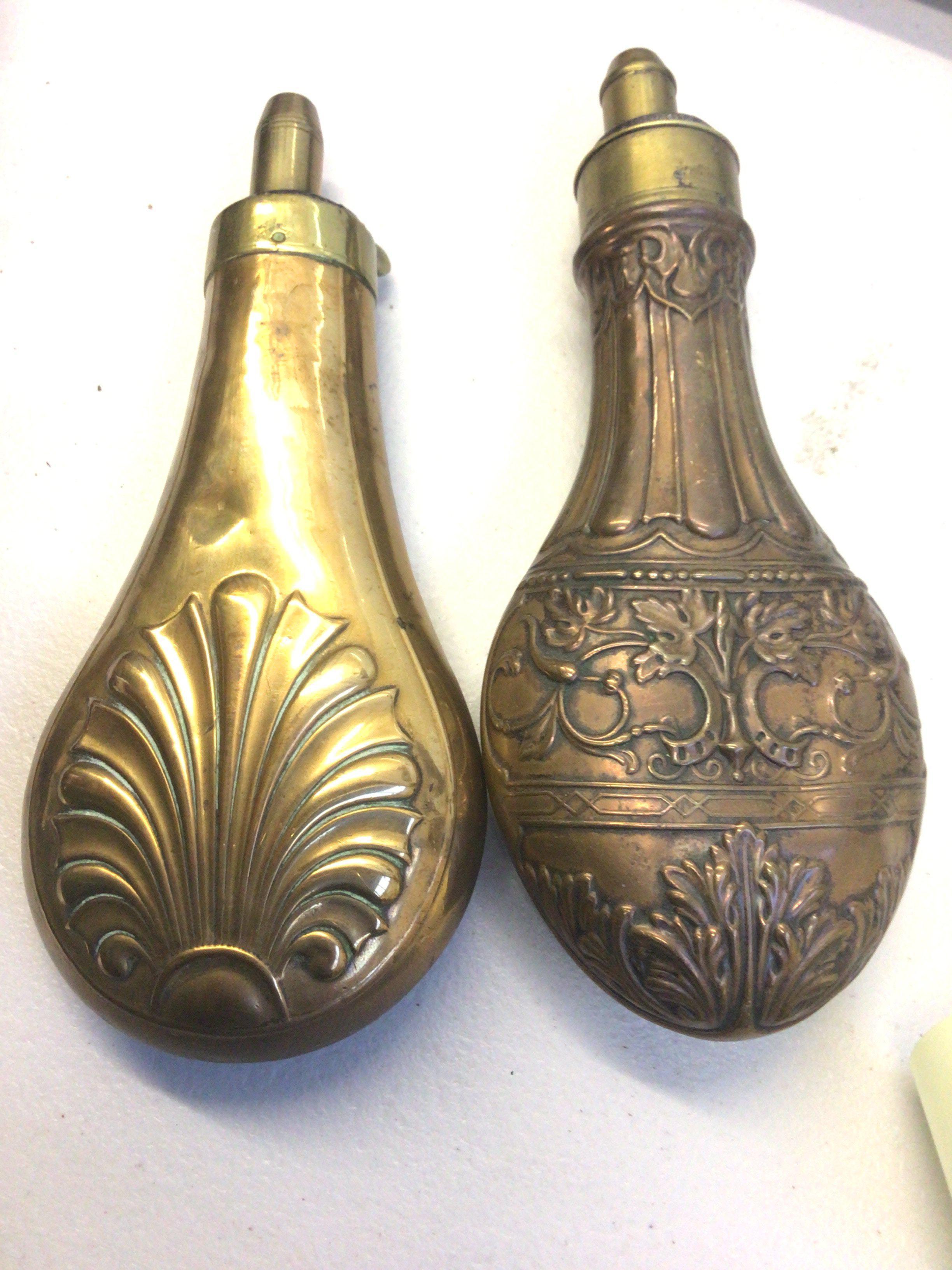 Two 19th century brass and copper powder flasks Repousse chased with a floral pattern. (2)