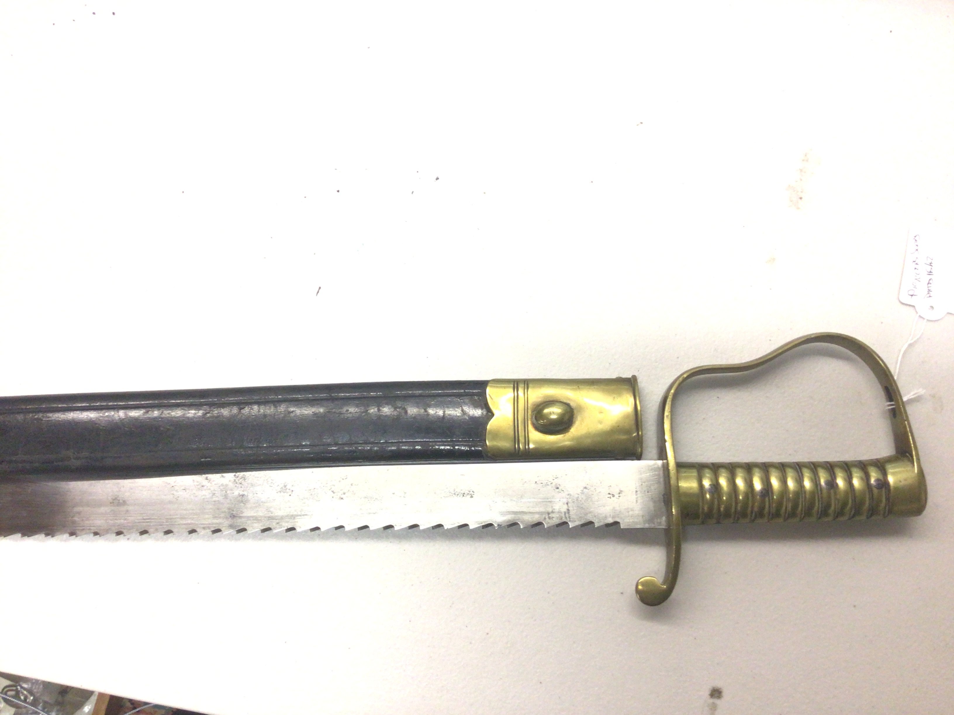 An 1856 British Pioneer sawback bayonet, the blade marked to one side with B 47 with crown above. With leather scabbard brass fittings a good example.