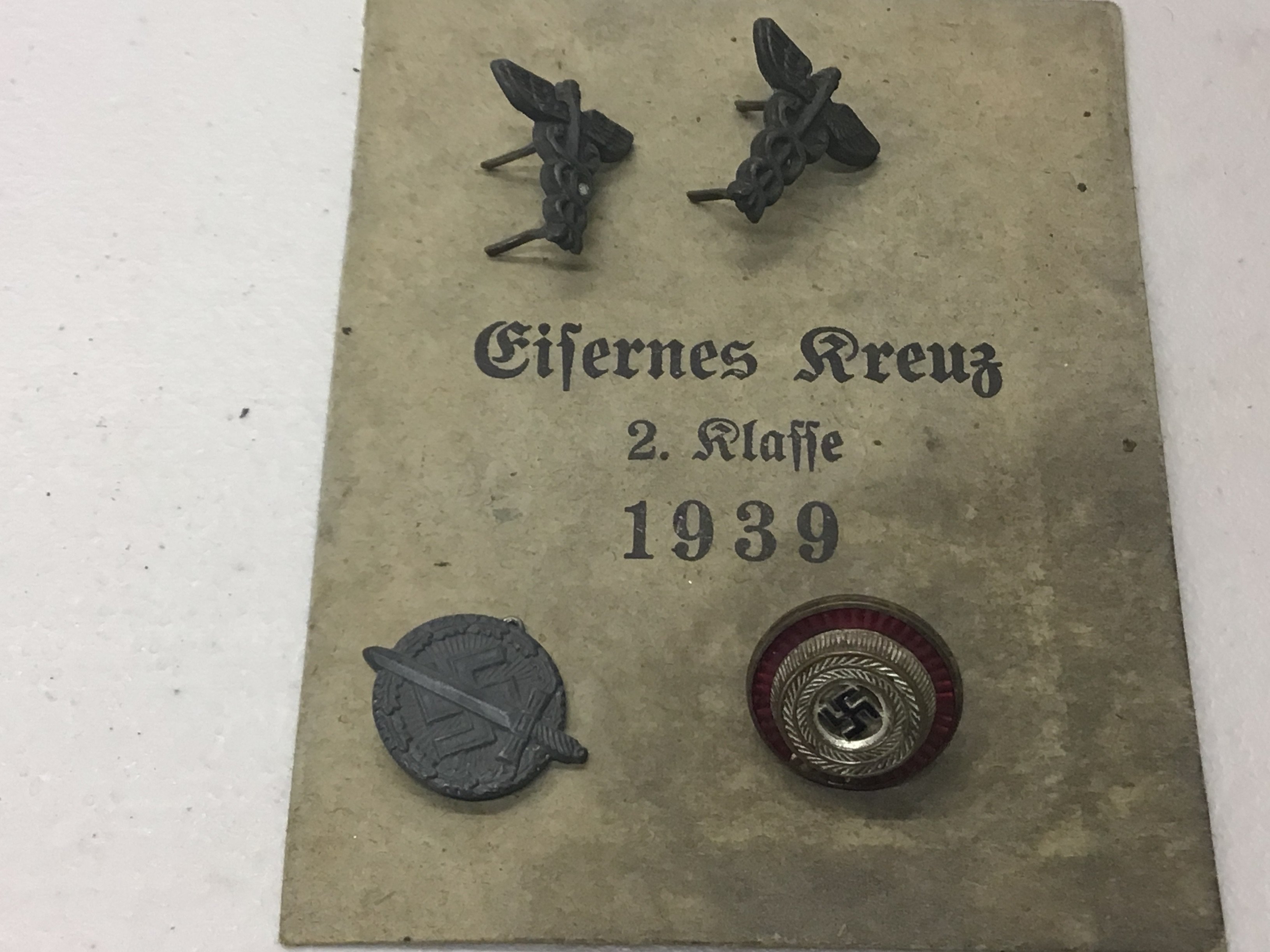A collection of German Third Reich party badges and others with a 1939 envelope.