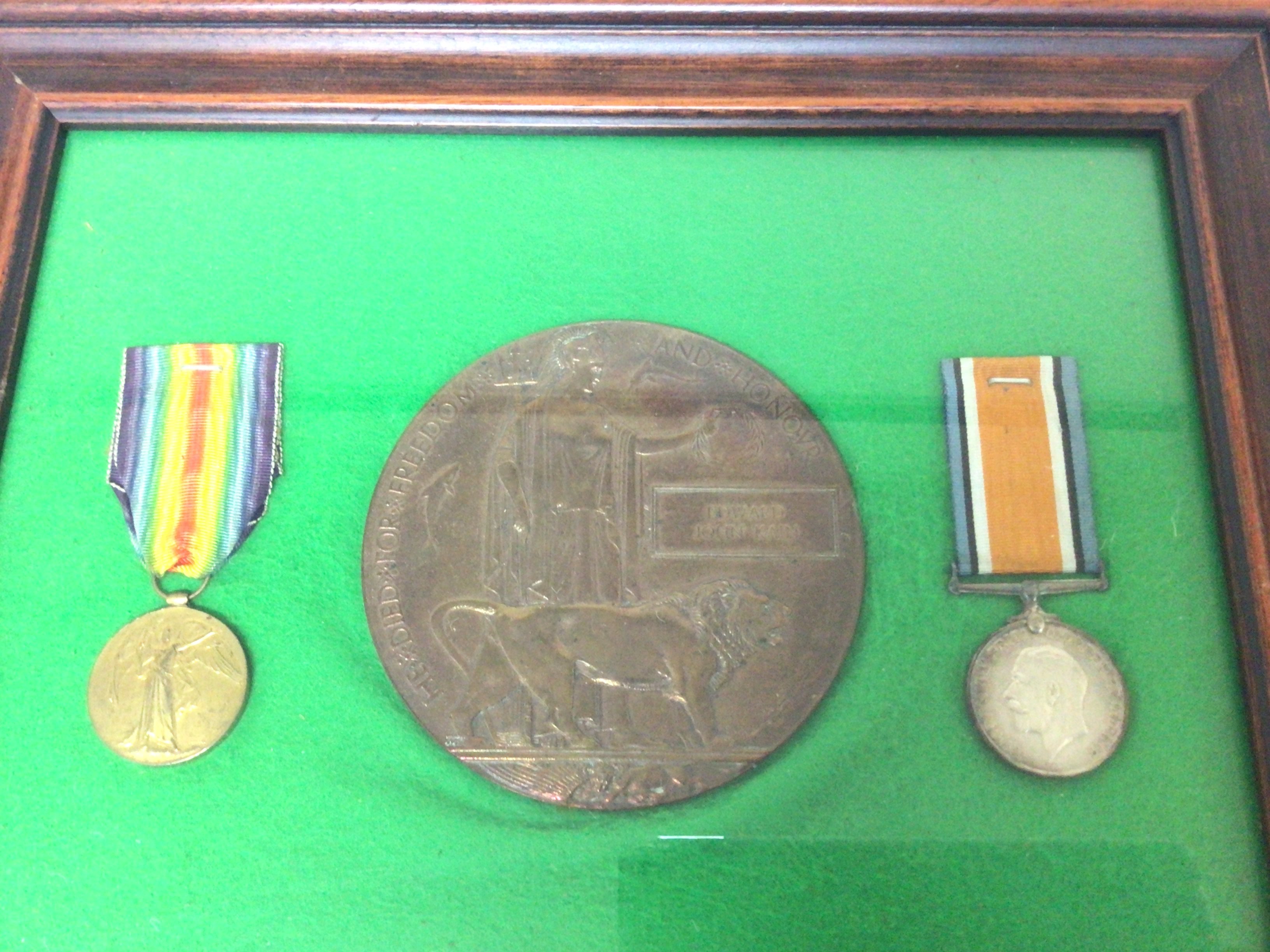 A Framed I World war Medal group and Memorial plaque awarded to Edward John Kain. The frame sealed.