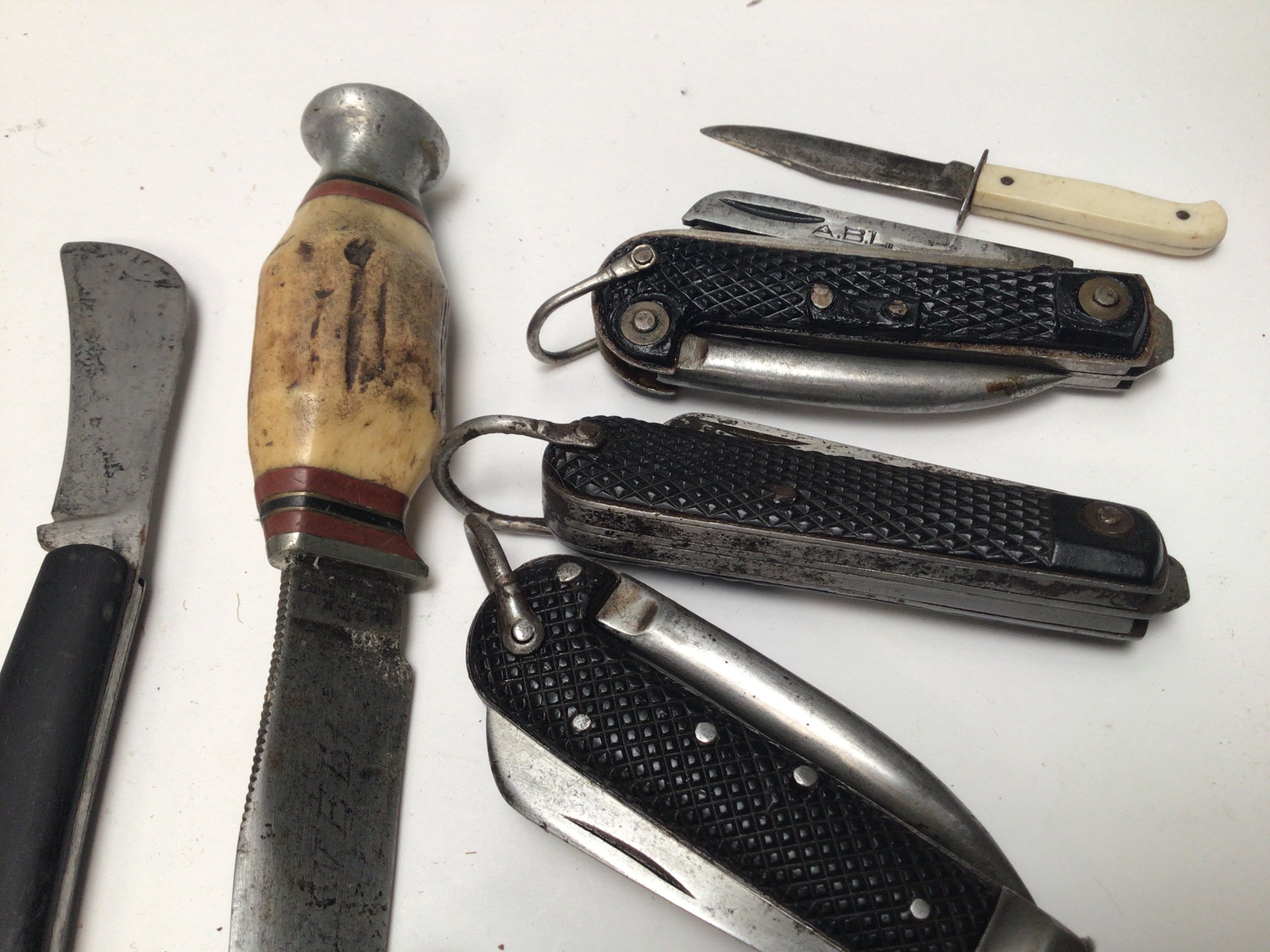 A collection of Vintage folding multi purpose pocket knifes a small vintage hunting Knife with a horn handle.