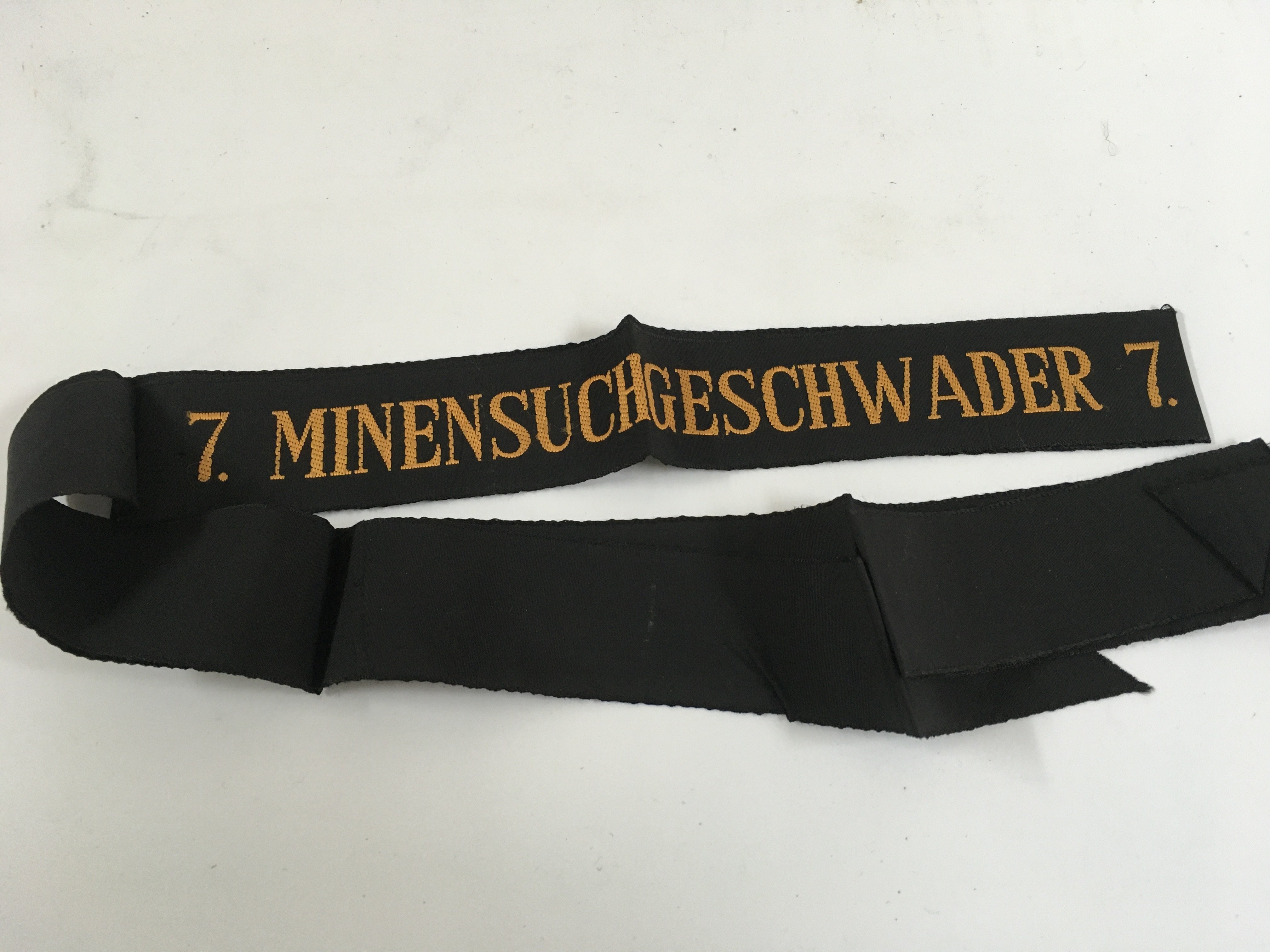 A collection of naval cap tallys consisting of a cap tally showing on it the vessel HMS Neptune, cap tally from the Royal Navy HMS Pembroke, cap tally from the royal naval vessel HMS Sultan, cap tally from the Royal Naval training base HMS Raleigh, cap tally from the royal naval vessel HMS Dryad and cap tally from German ship minensucher geschwader 1
