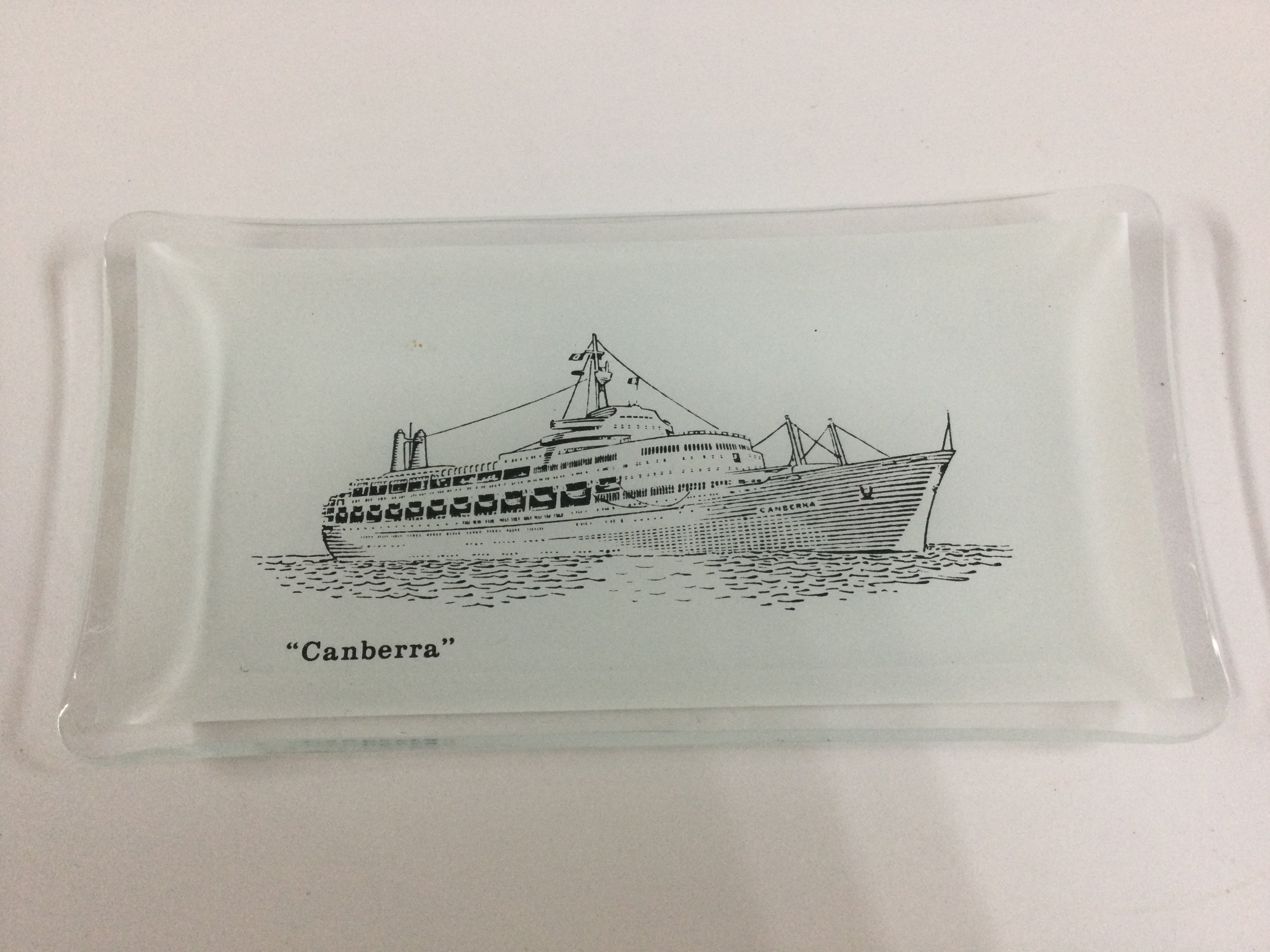 A collection of maritime glass items consisting of early Fred Olsen line shipping company souvenir glass paperweight from the 1970s, glass ashtray from the Mac Andrew line shipping company, superb champagne glass souvenir celebrating the 25th anniversary of the cruise line princess cruises, souvenir glass dish from the P&O vessel the Canberra, glass paperweight souvenir from the vessel the SS Dartington and a rare to find original glass ashtray from the Harrison line shipping company