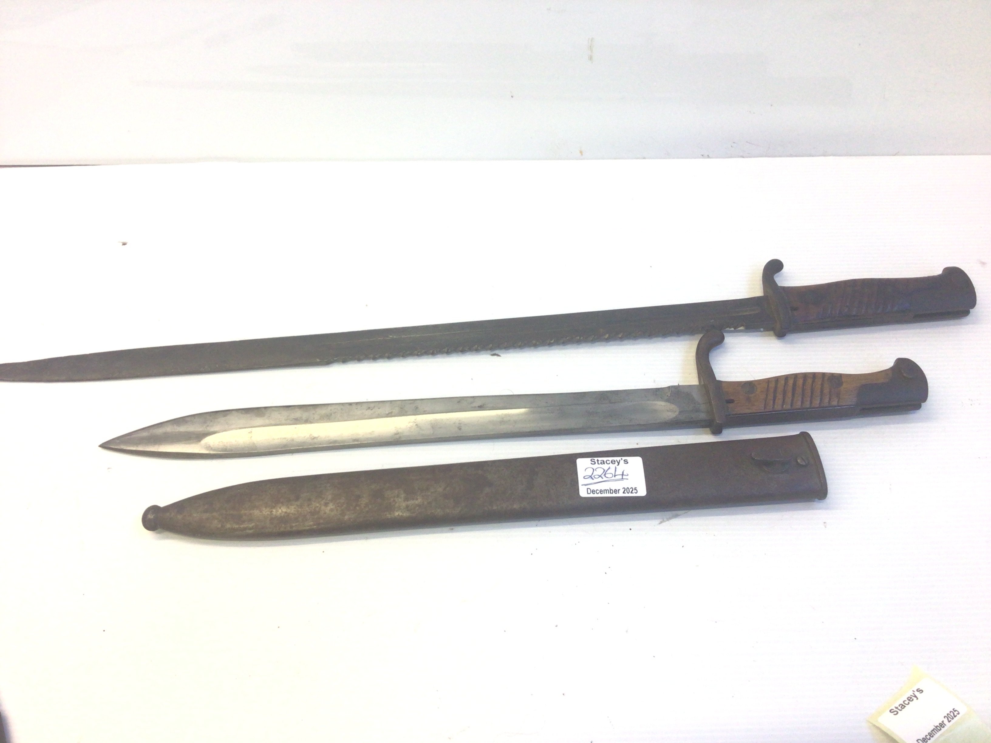 A German Imperial unusual saw bayonet no scabbard and a standard German butchers bayonet with steel scabbard. (2)