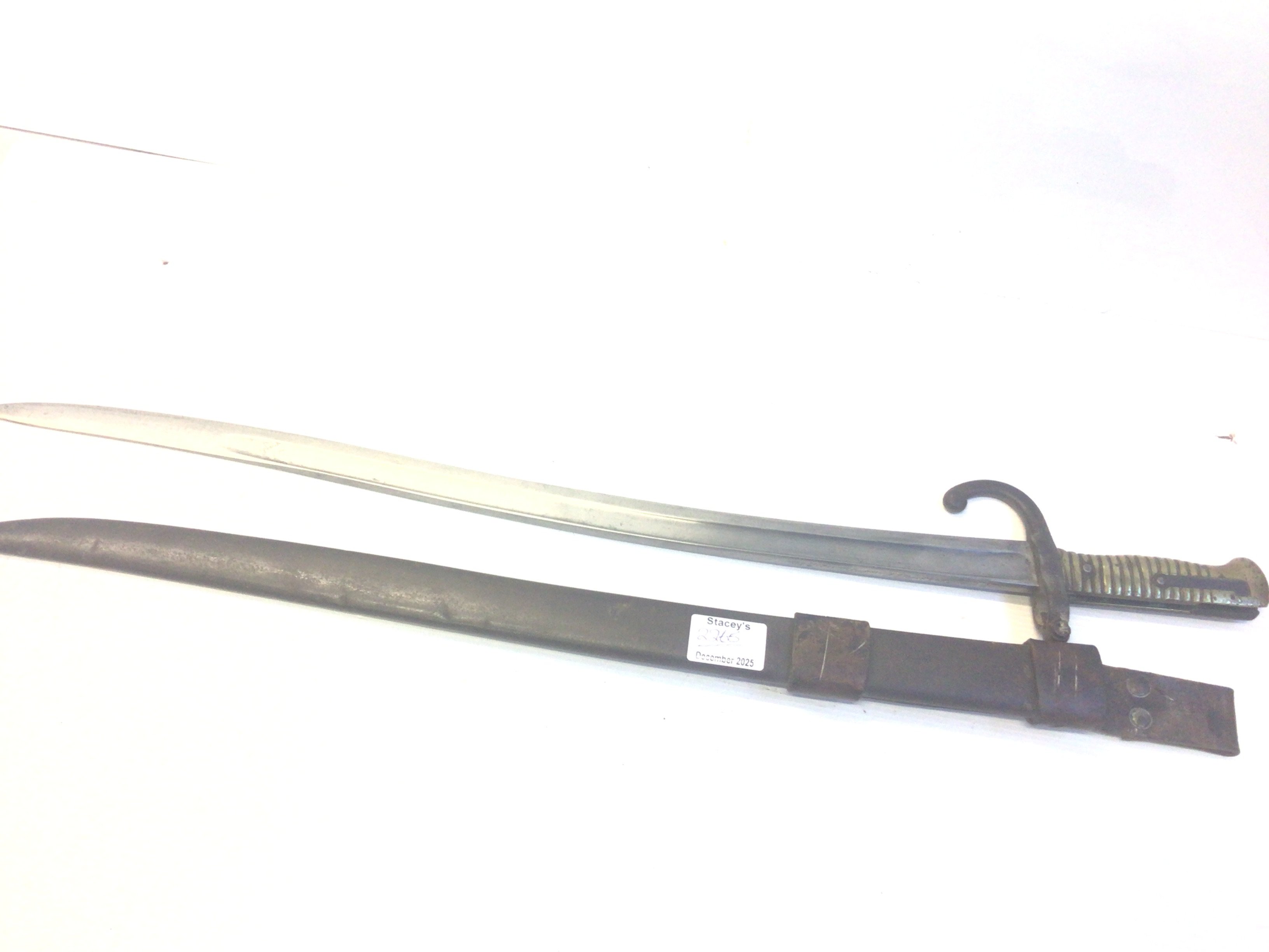 A French 19th century Chasspot bayonet with an engraved steel blade edge and brass grip with steel scabbard. With attached leather frog.
