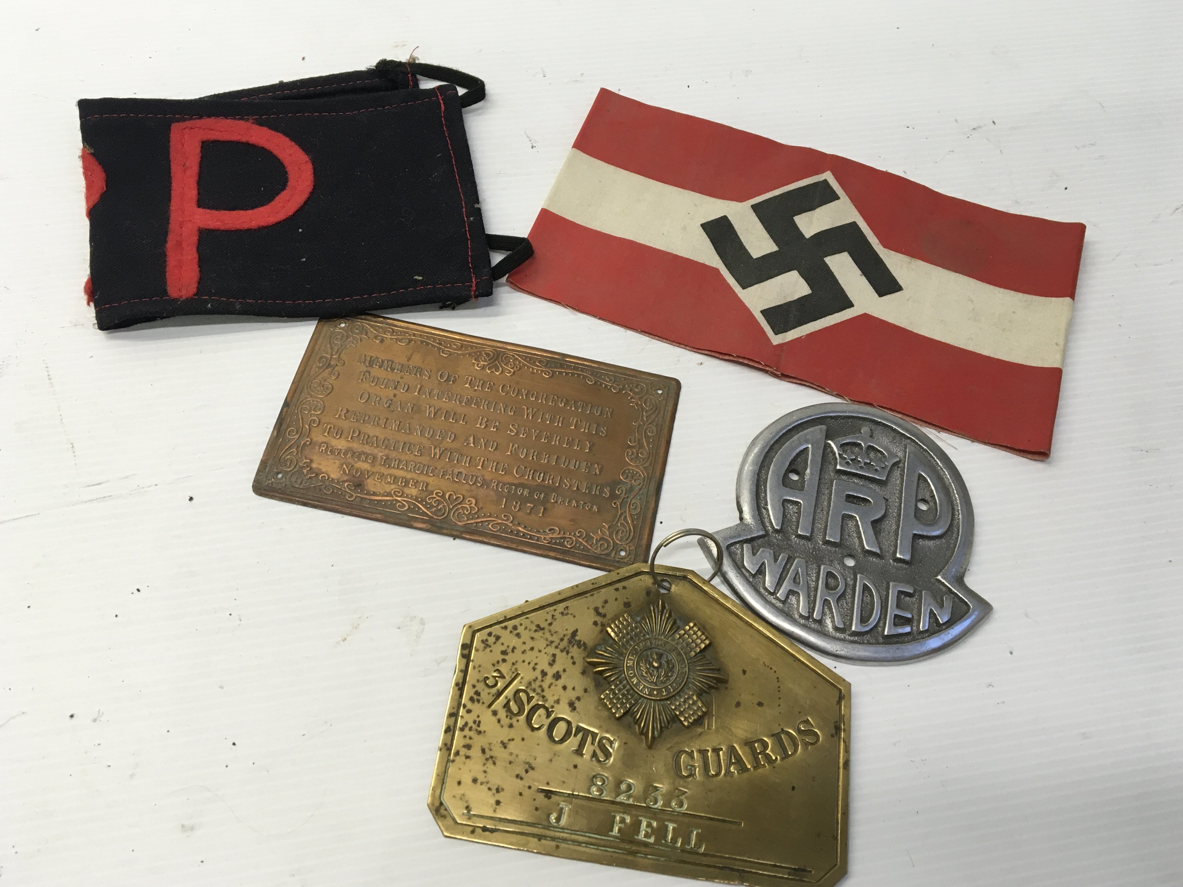 A German Third Reich political armband a cast aluminium ARP warden badge Scots Gaurd badge RP armband and one other plaque.