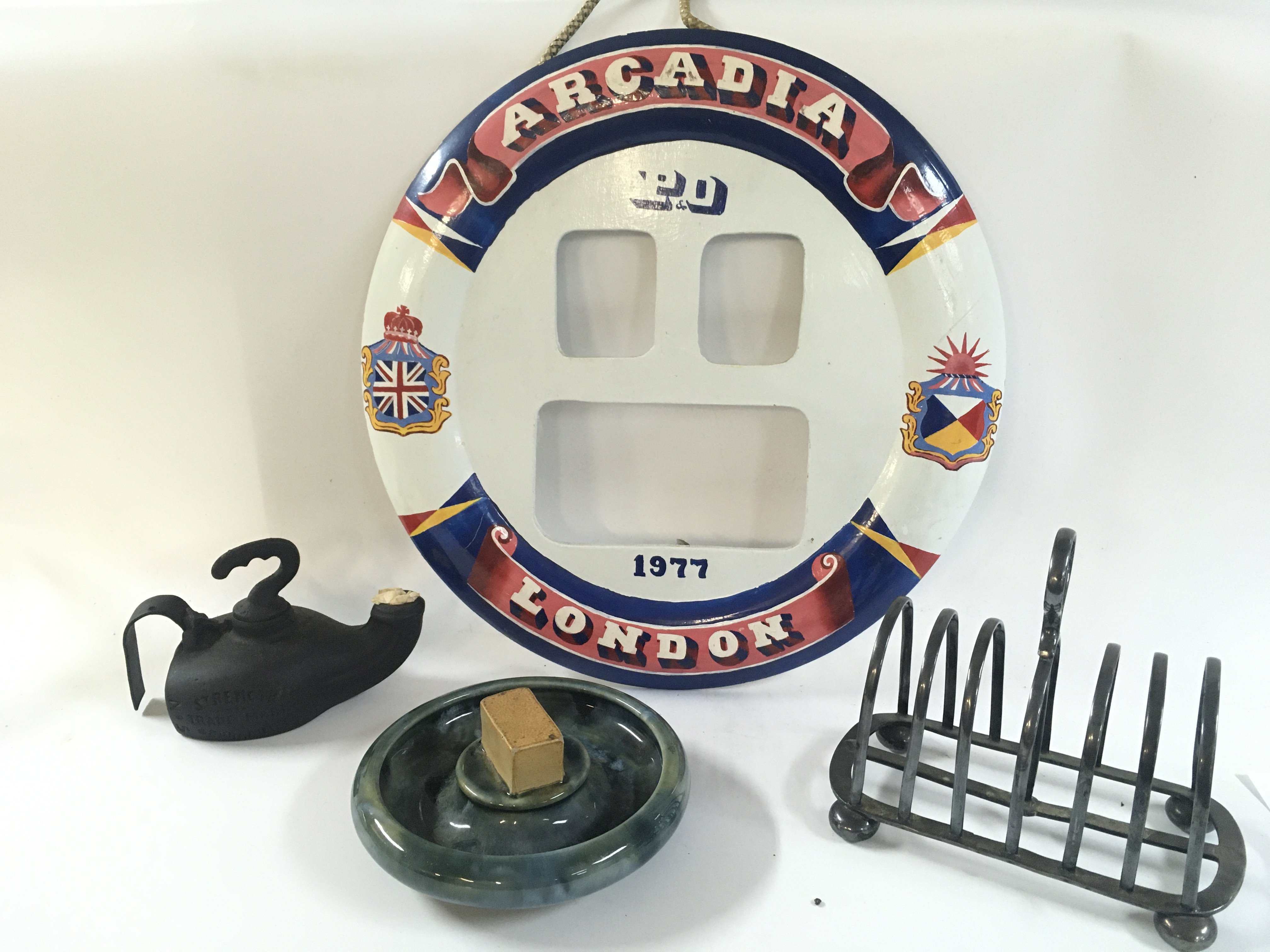 A collection of rare maritime artefacts including a silver plated toast rack from the ship the star of Victoria , hand crafted and painted wooden lifebelt model from the Arcadia, very early and excellent condition lounge ashtray from the P&O line , single torch lamp from the British India steam navigation