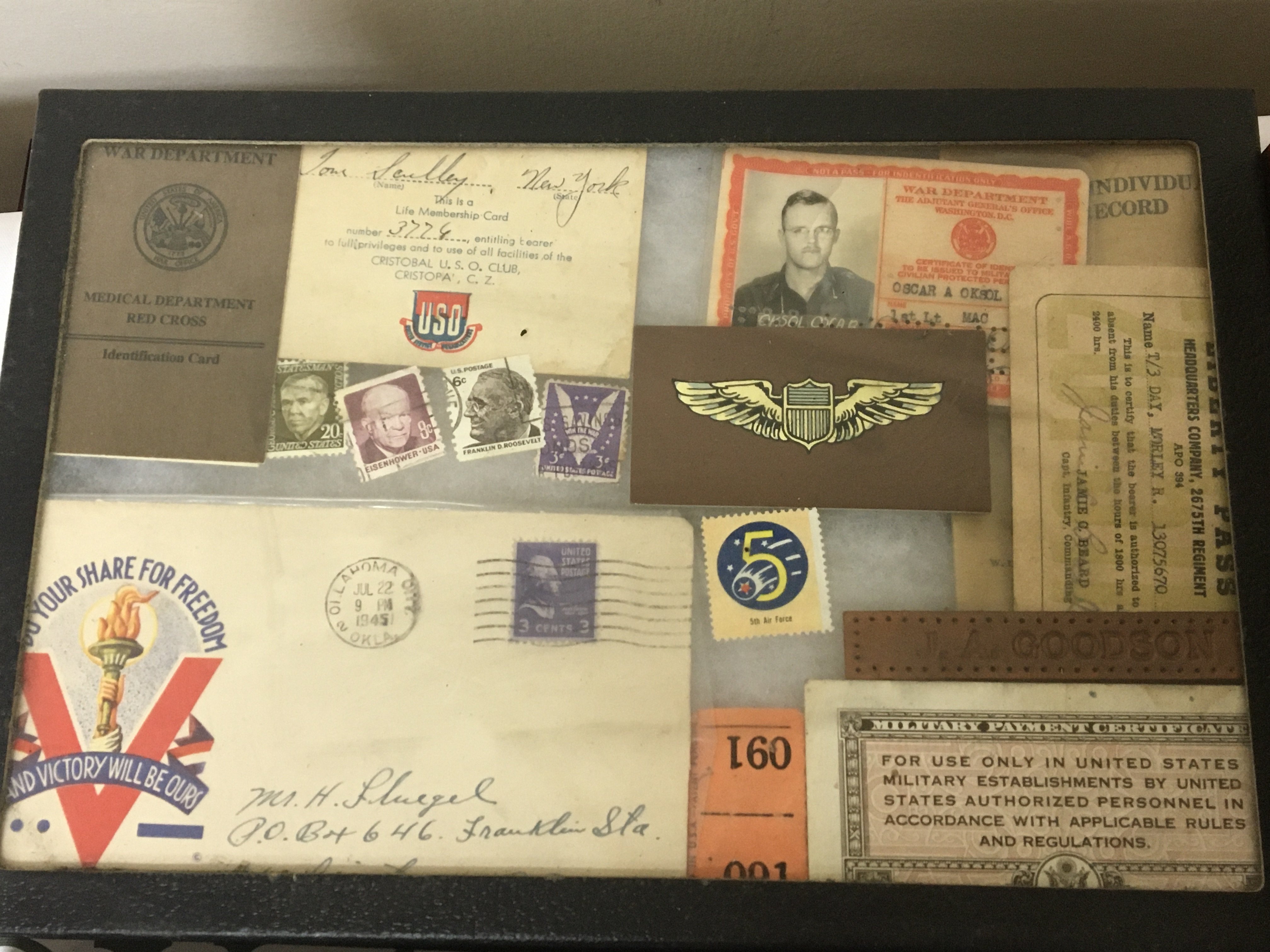 Three display cases containing American War period issue packaging lighters and playing cards.