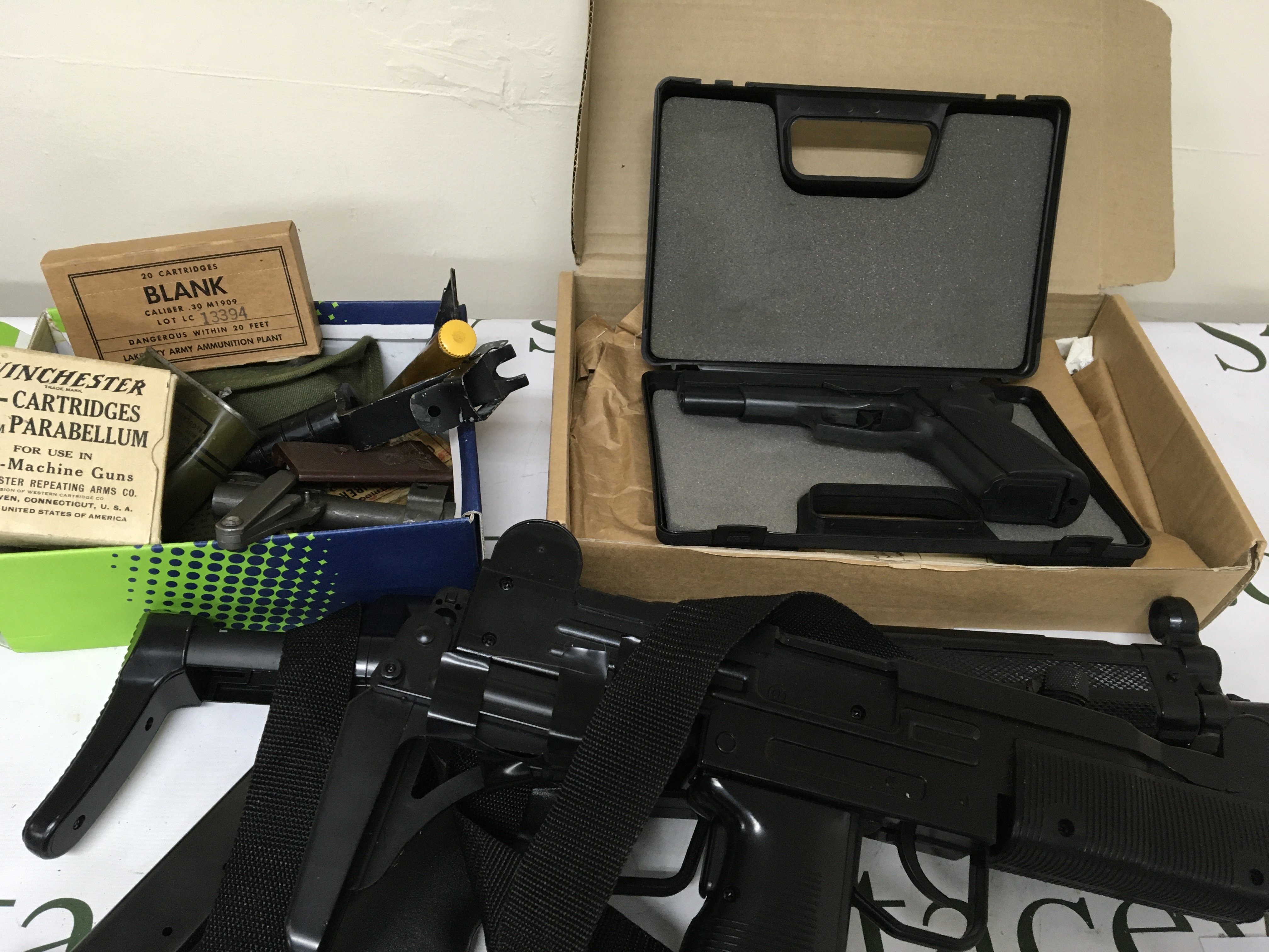 A box containing American empty vintage Cartridges and other oddments cases a blank firing Browning GP DA8 in a fitted case two plastic non firing replica machine guns.