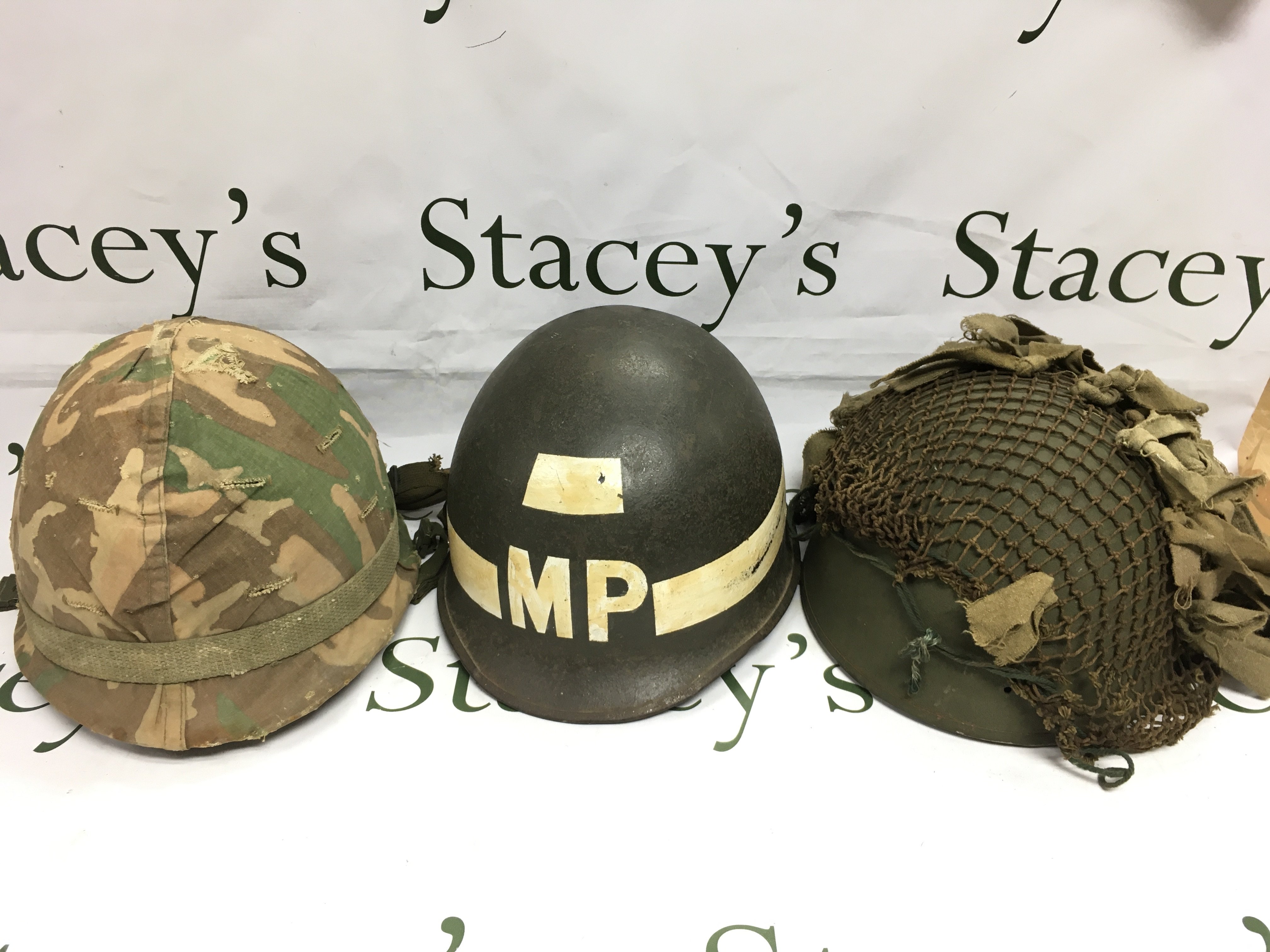 A Military Police helmet and two other 20th Century helmets (3). Shipping category C.