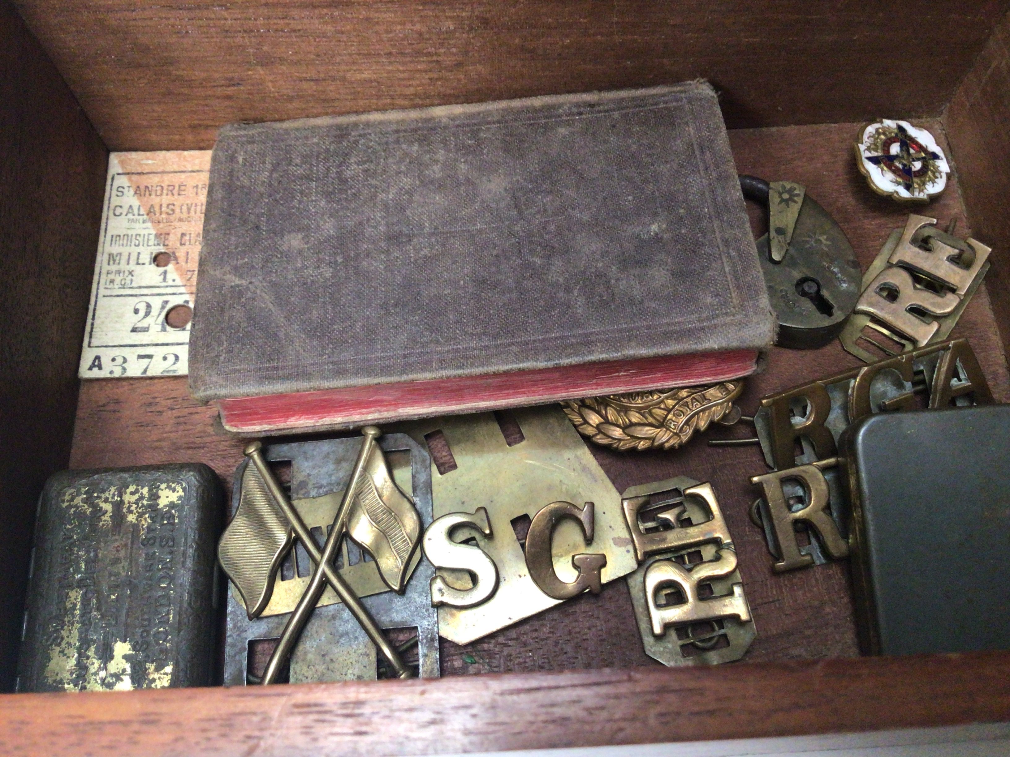A box containing British military badges.