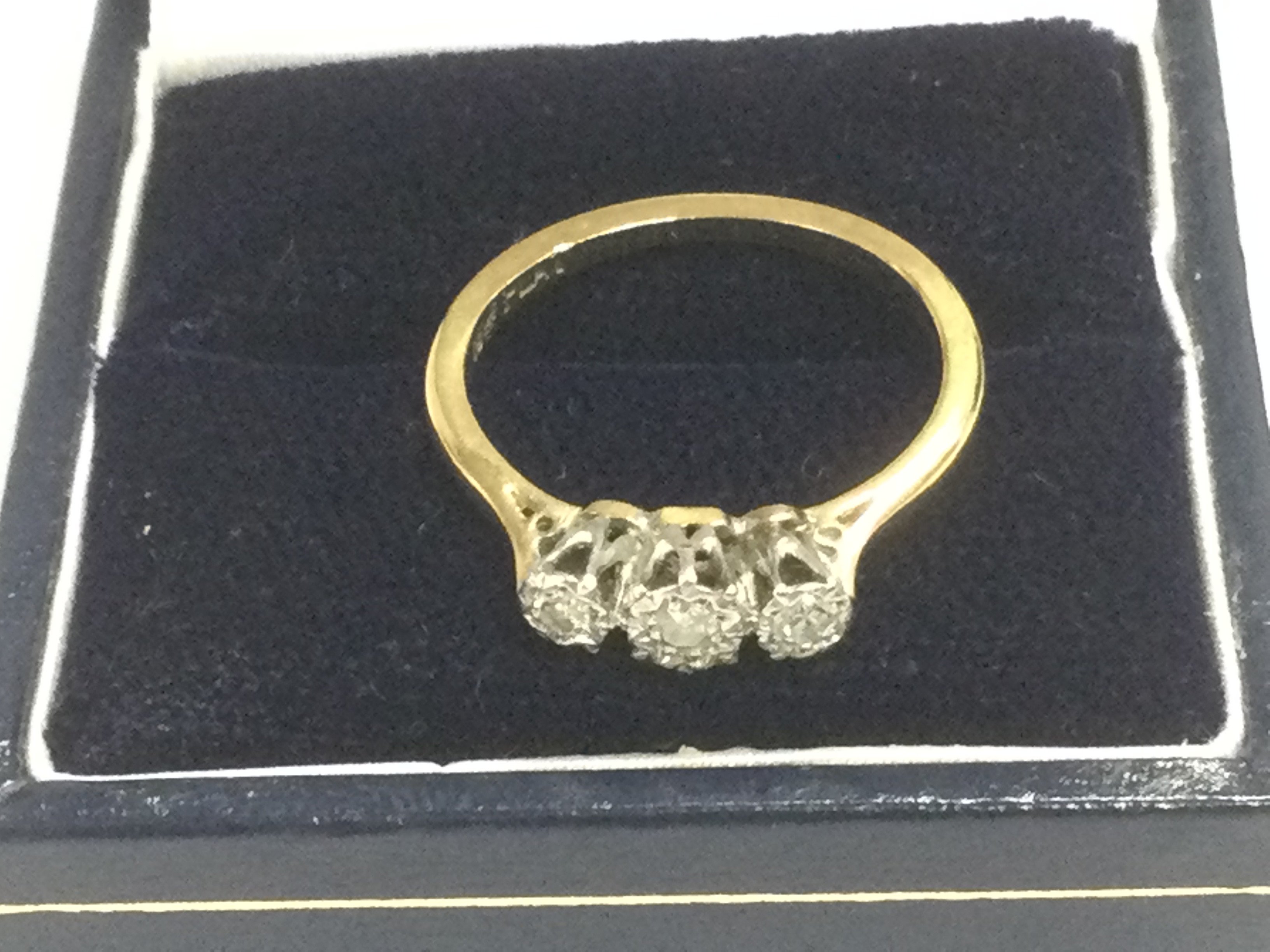 An 18ct gold and platinum three stone diamond ring, approx 2.6g and approx size L-M. Shipping category A.