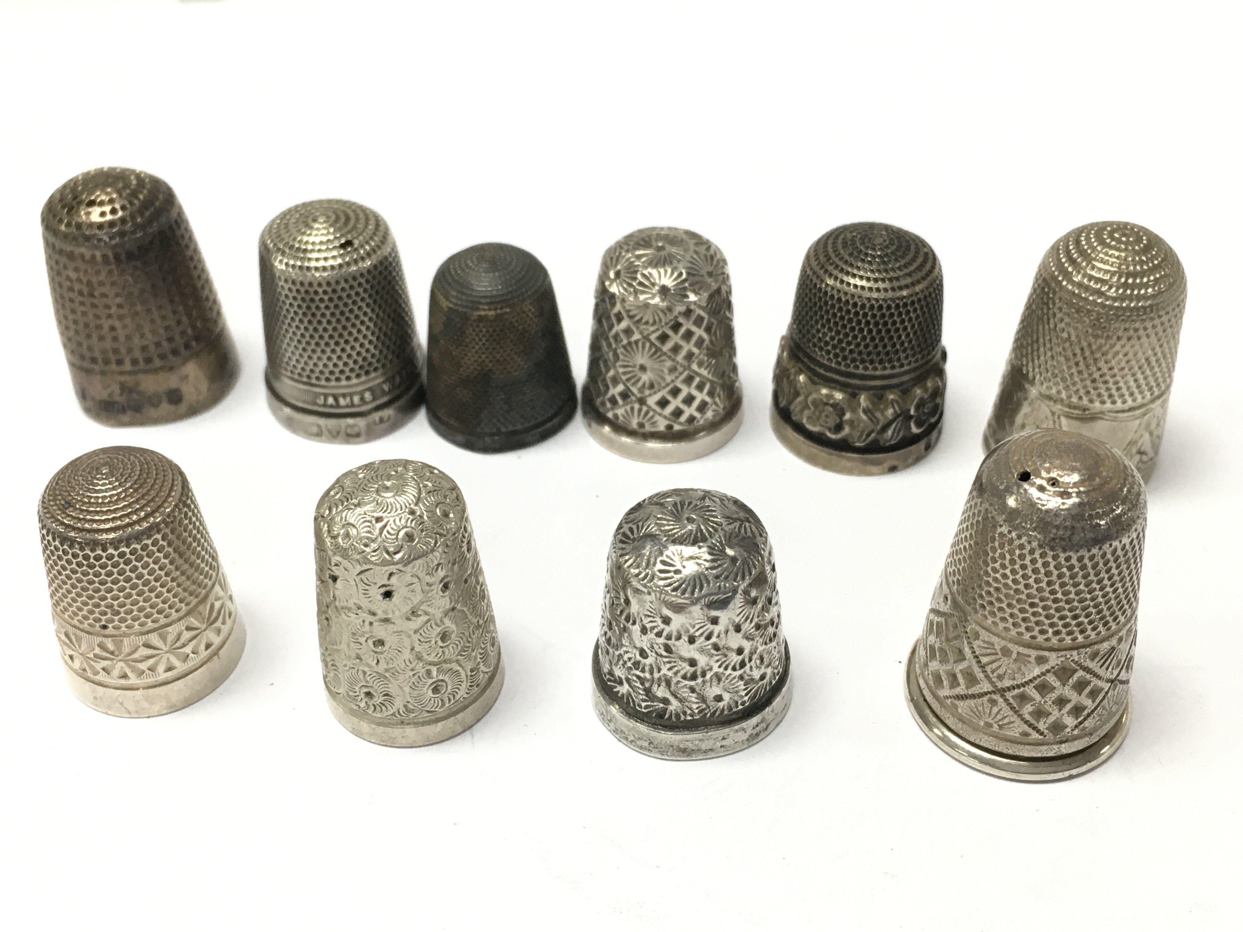 A collection of silver thimbles , postage category A