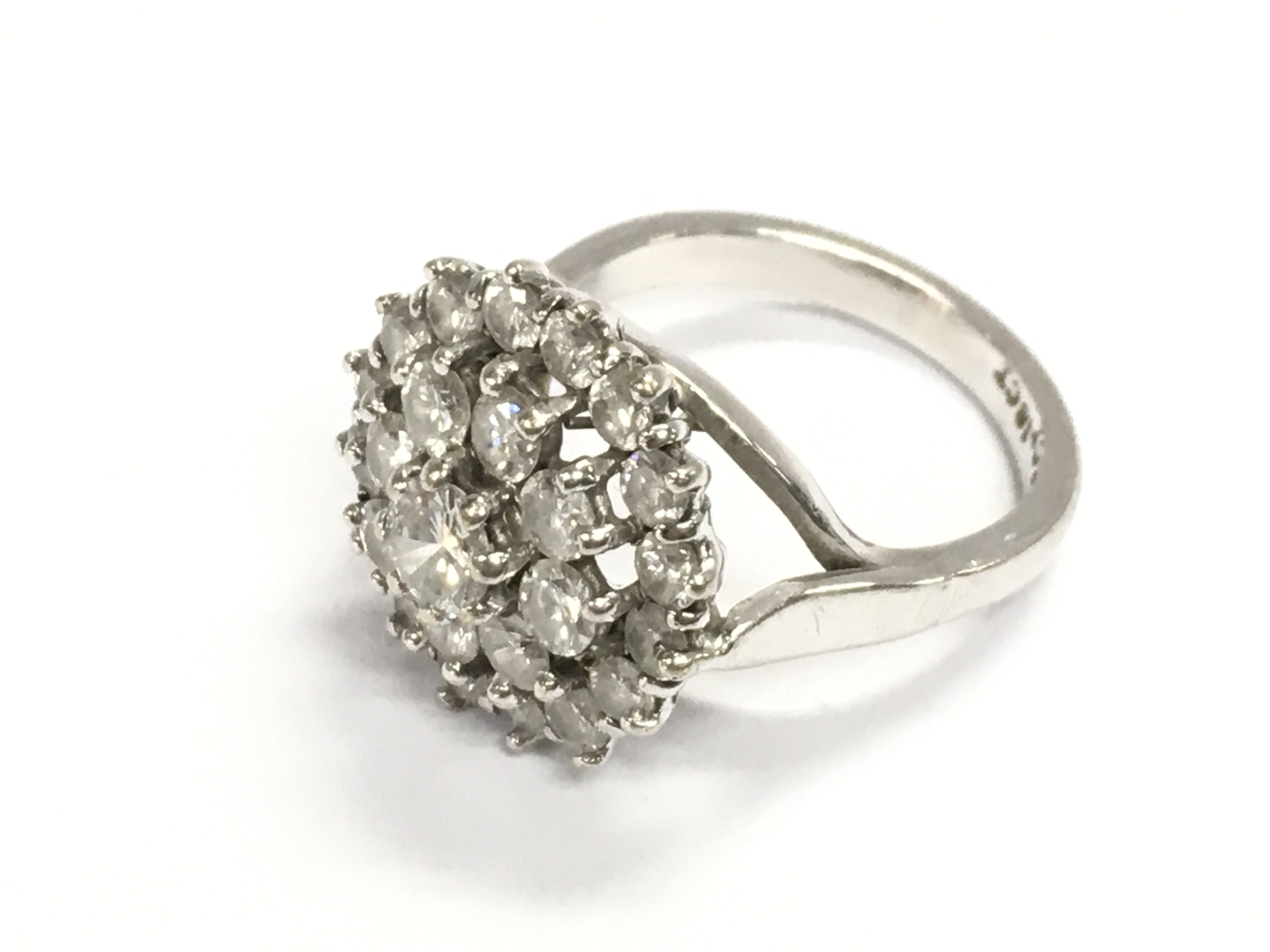 An 18ct white gold diamond cluster ring. Size N and 8.15g Central diamond is approximately 0.50ct and approximately 3.2ct total in diamonds
