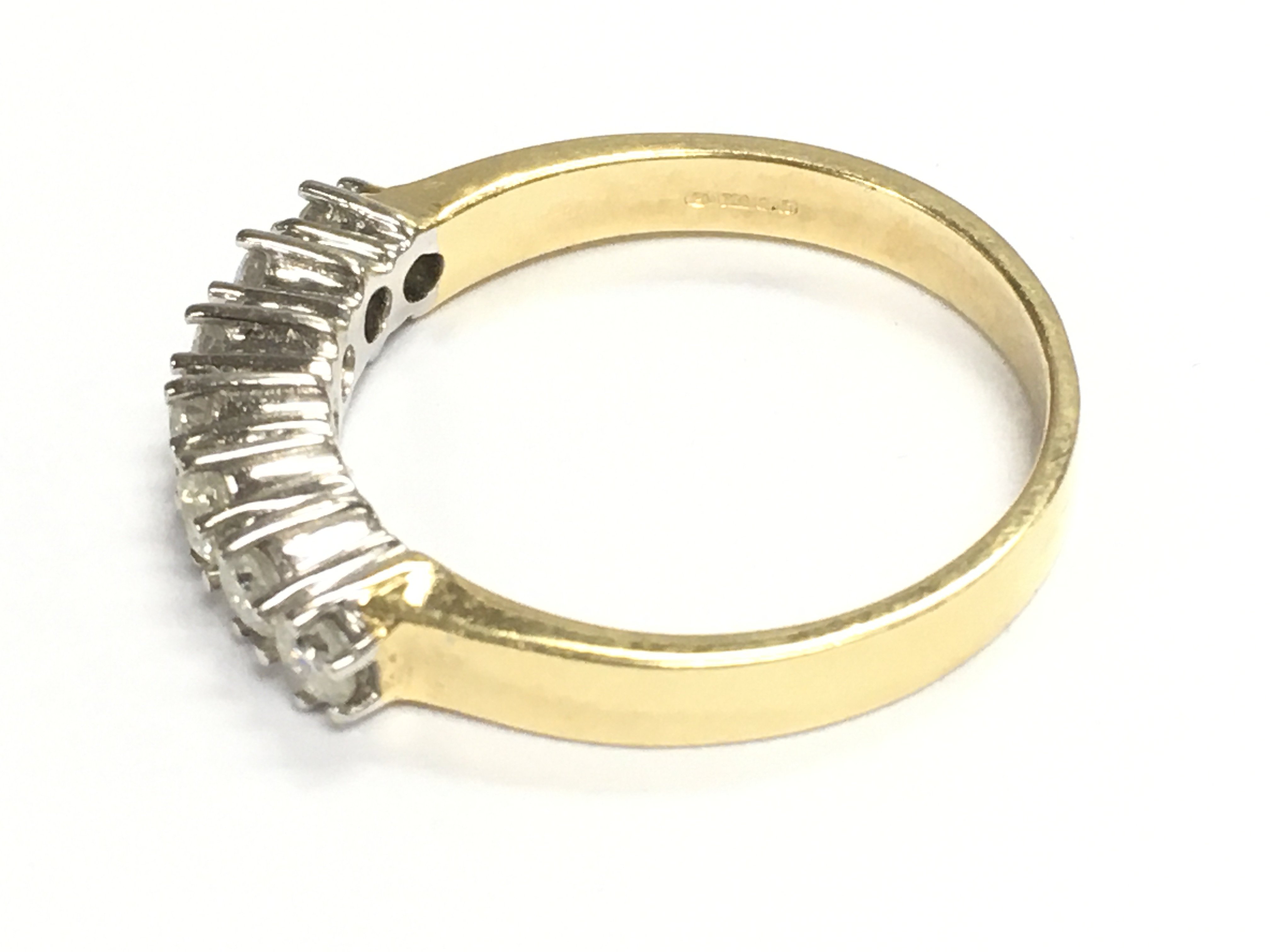 An 18ct gold diamond seven stone ring. Size M 1/2 and 3.71g Postage A