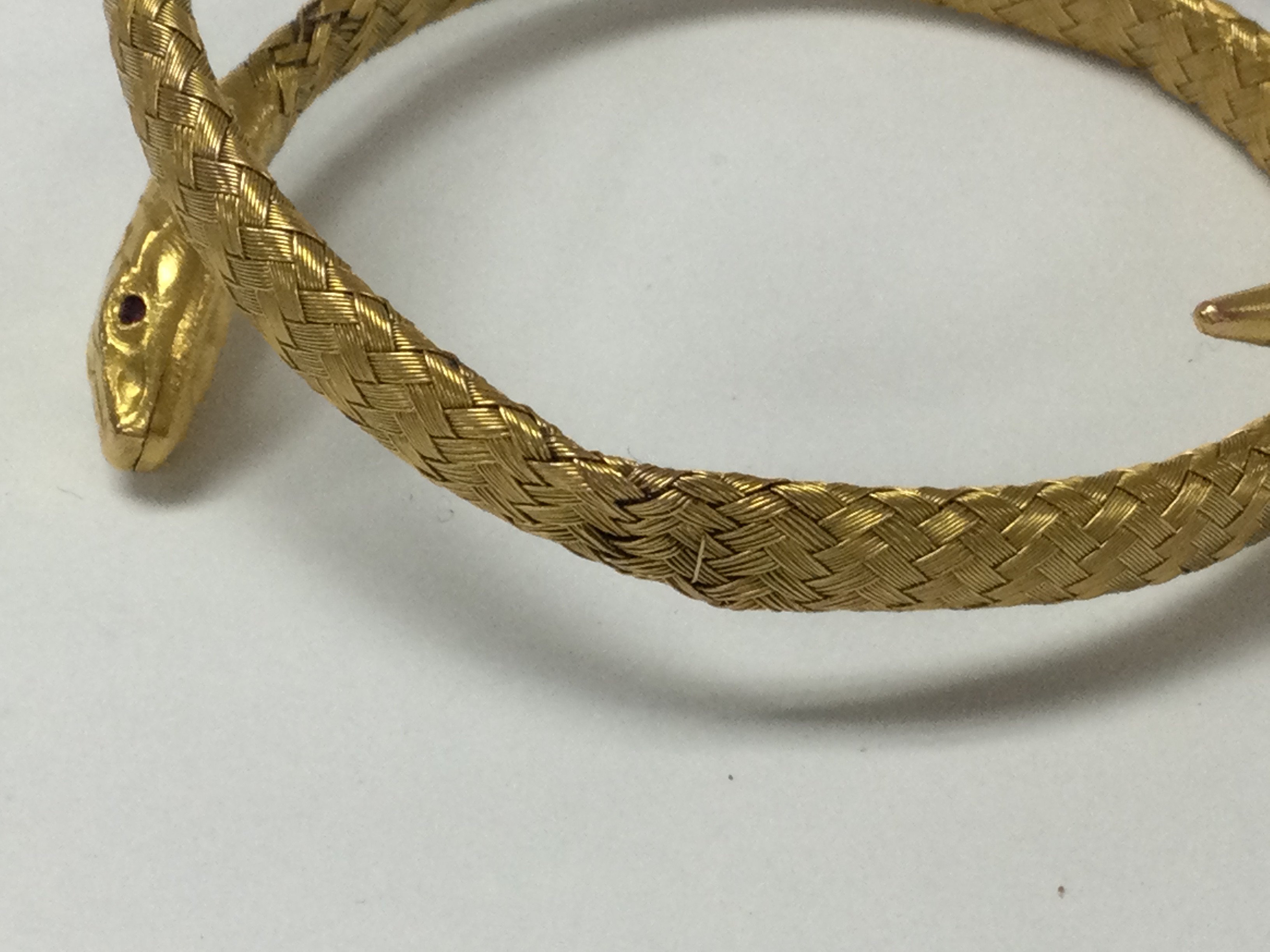 A gold bangle n the form of a serpent with rubie eyes .17 grams.
