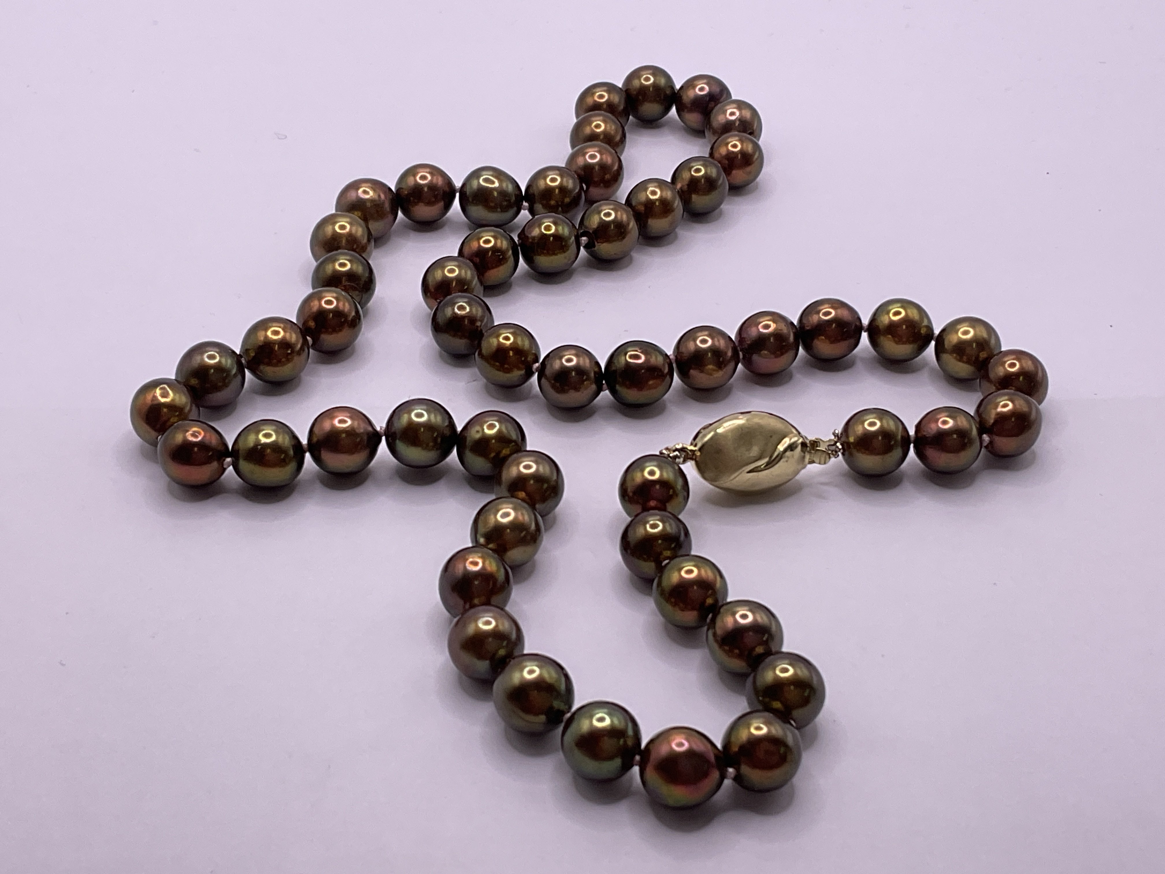 Necklace strung with chocolate coloured freshwater cultured pearls with an oval shaped 9ct yellow gold stain/polished style clasp. Postage category A.