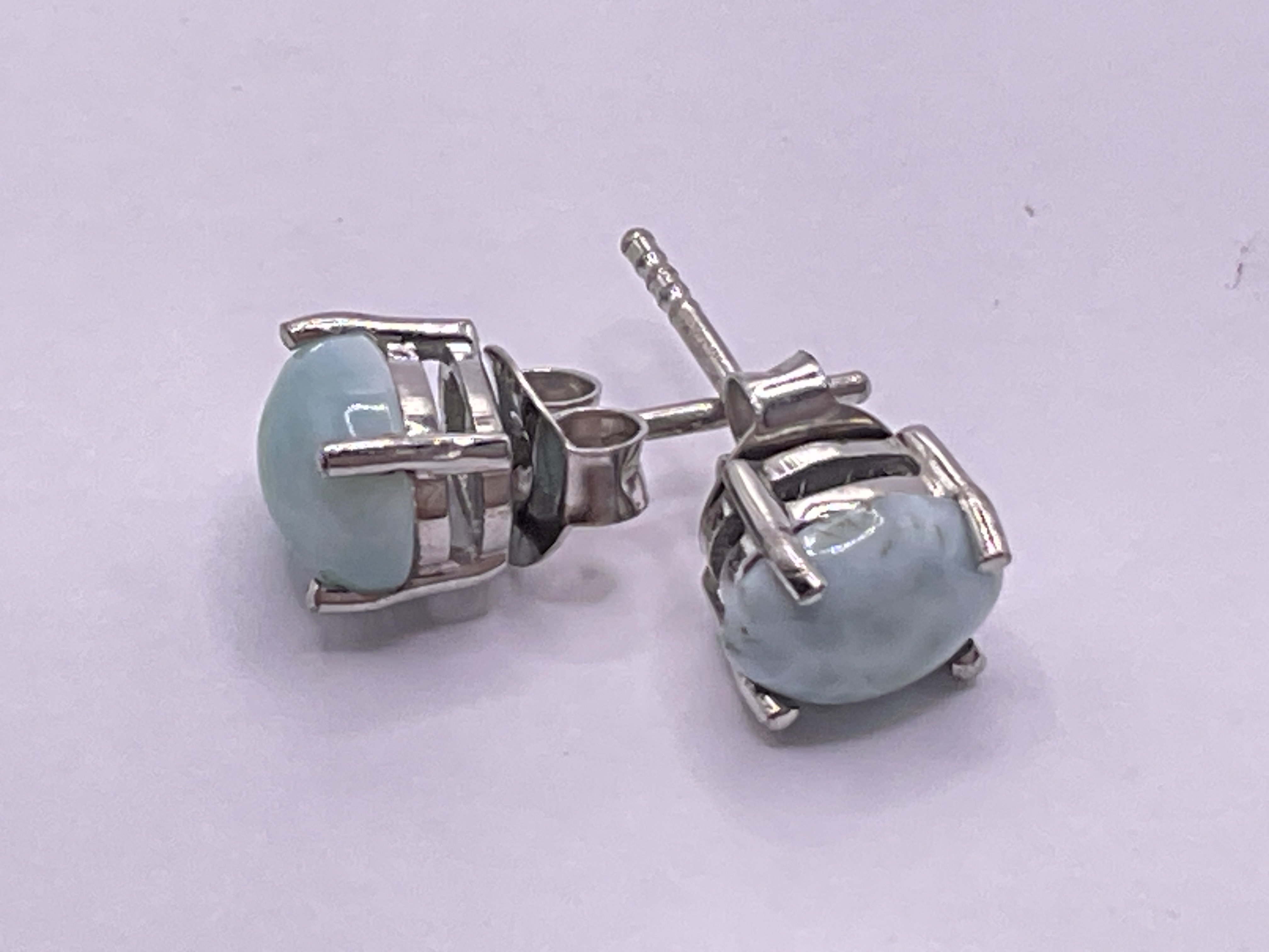 Pair of cabochon larimar studs in silver. Postage category A.