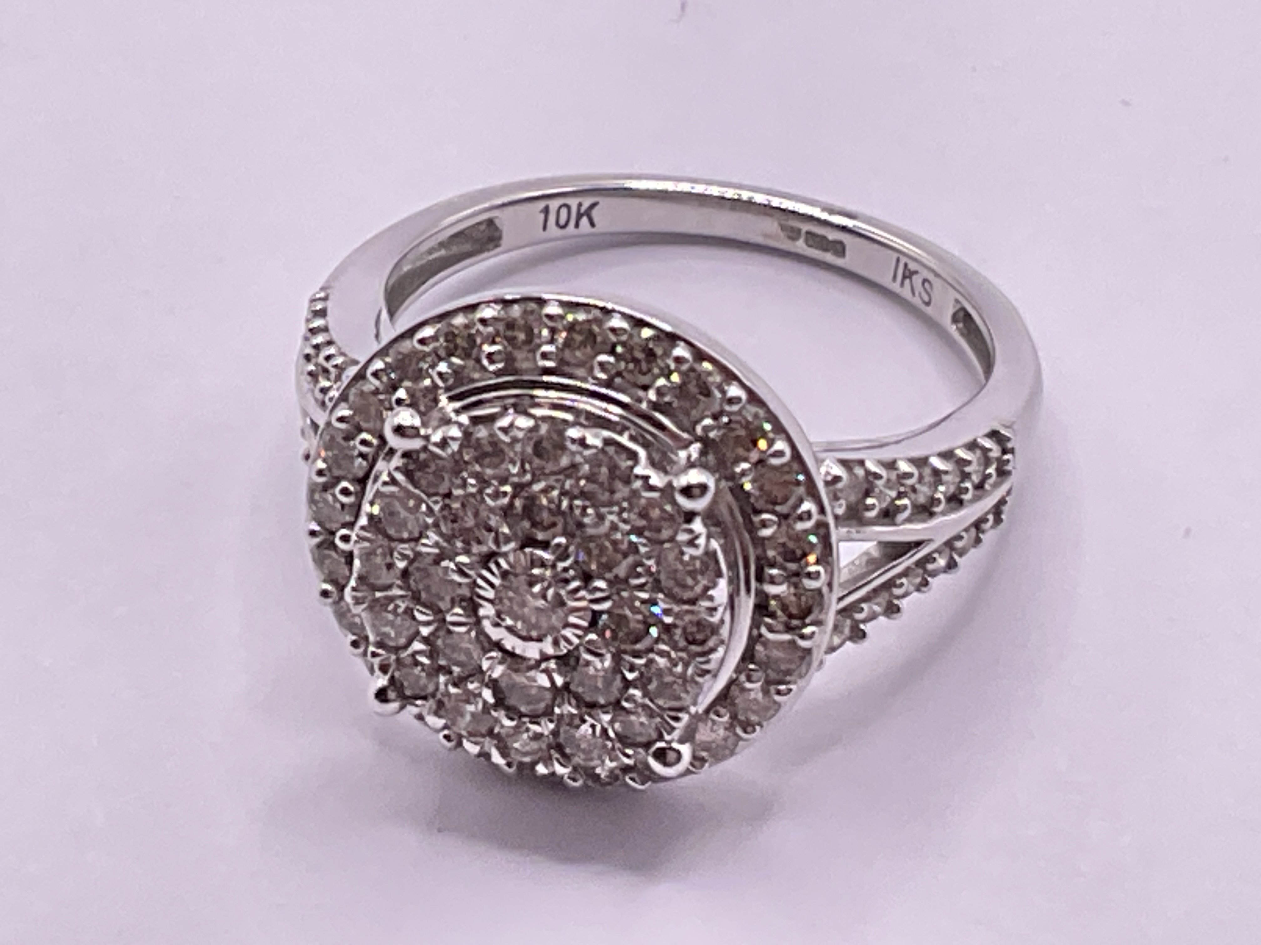 Large 9ct white gold diamond cluster ring with diamond set shoulders. RBC diamonds 1.00ct. Ring size approx N/O Postage category A.