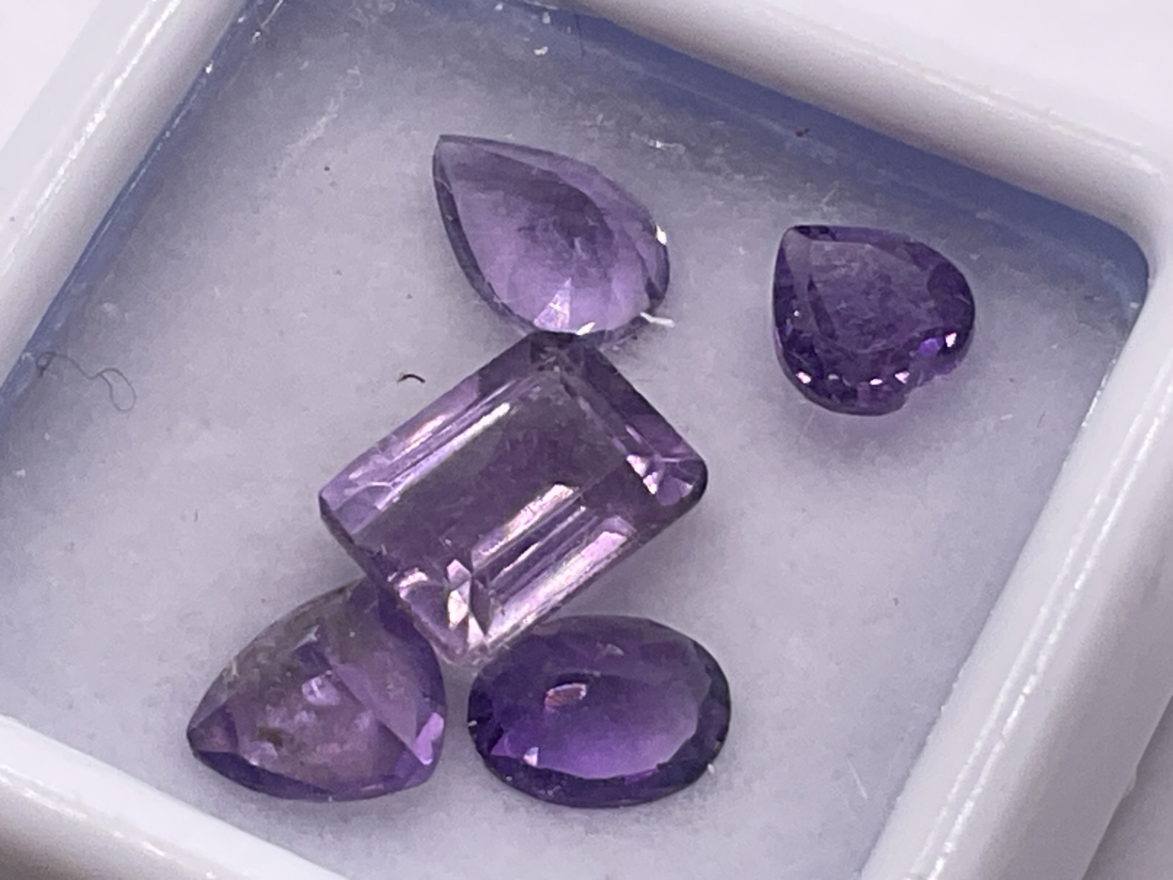 Parcel of 5 loose, unmounted amethyst gemstones in mixed cuts, boxed. 3.75ct. Postage category A.