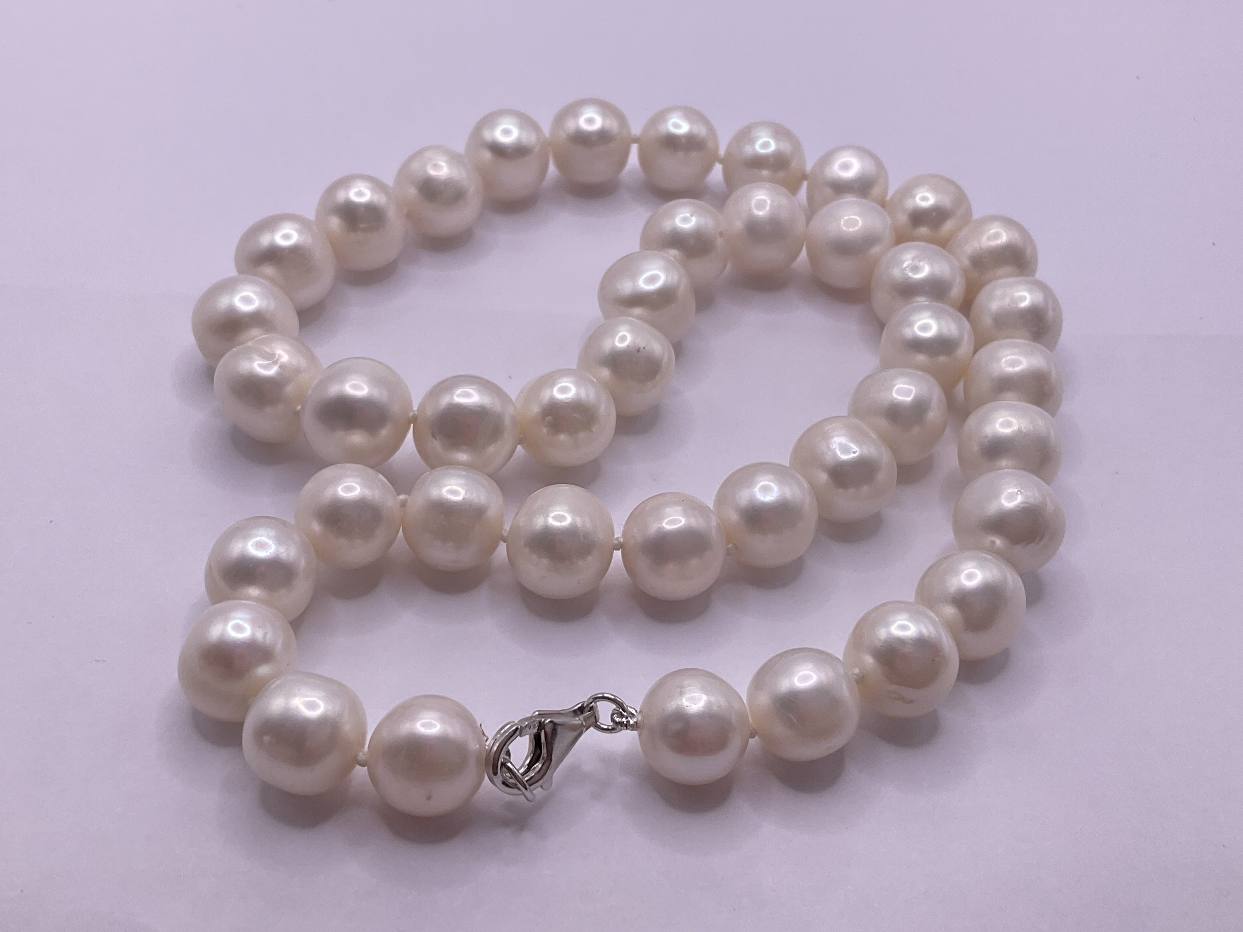 18&rdquo; white cultured Pearl necklace with a silver clasp. Postage category A.