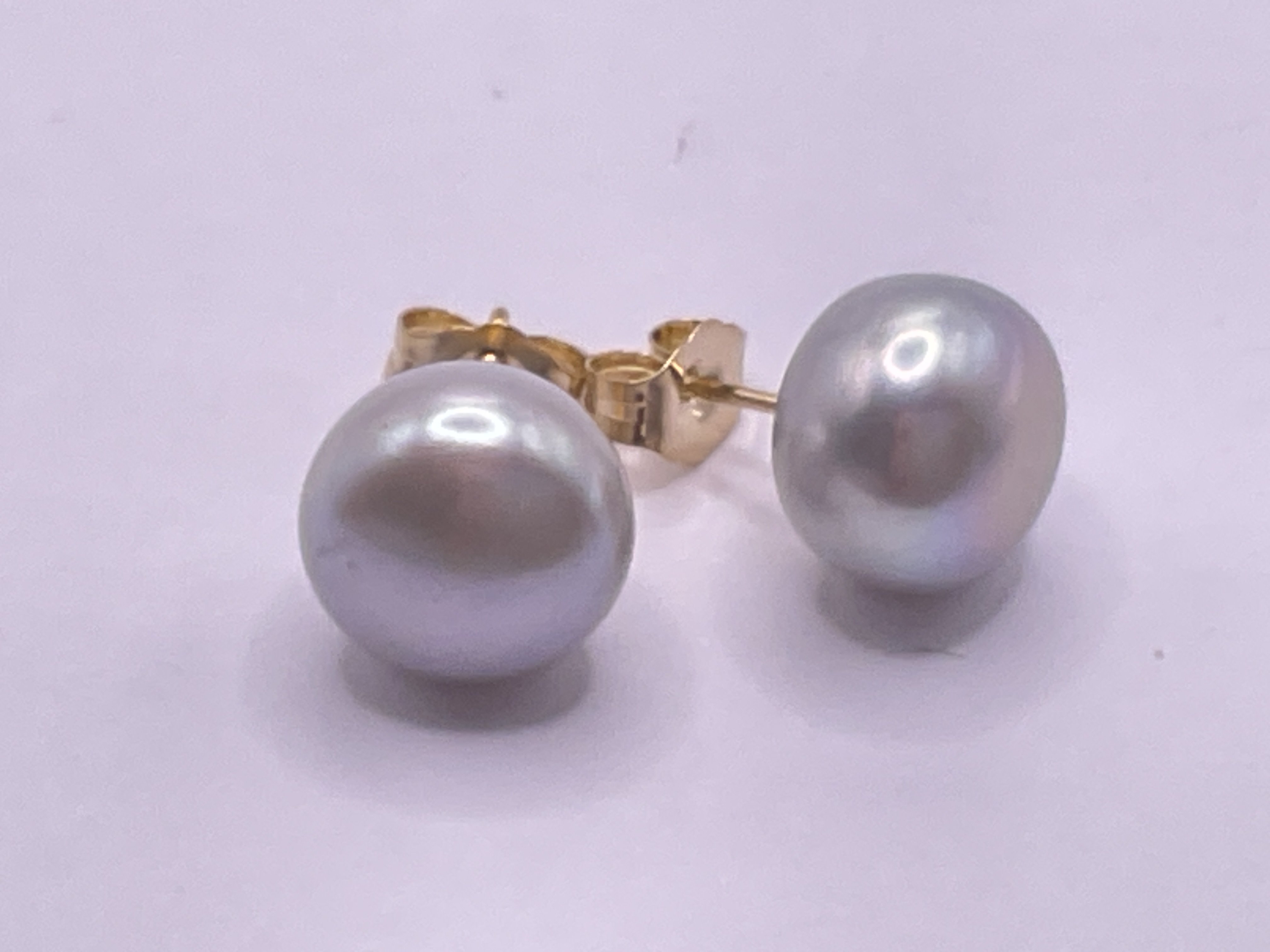 Pair of 9ct yellow gold studs set with oblate spheroid grey cultured pearls. Postage category A.