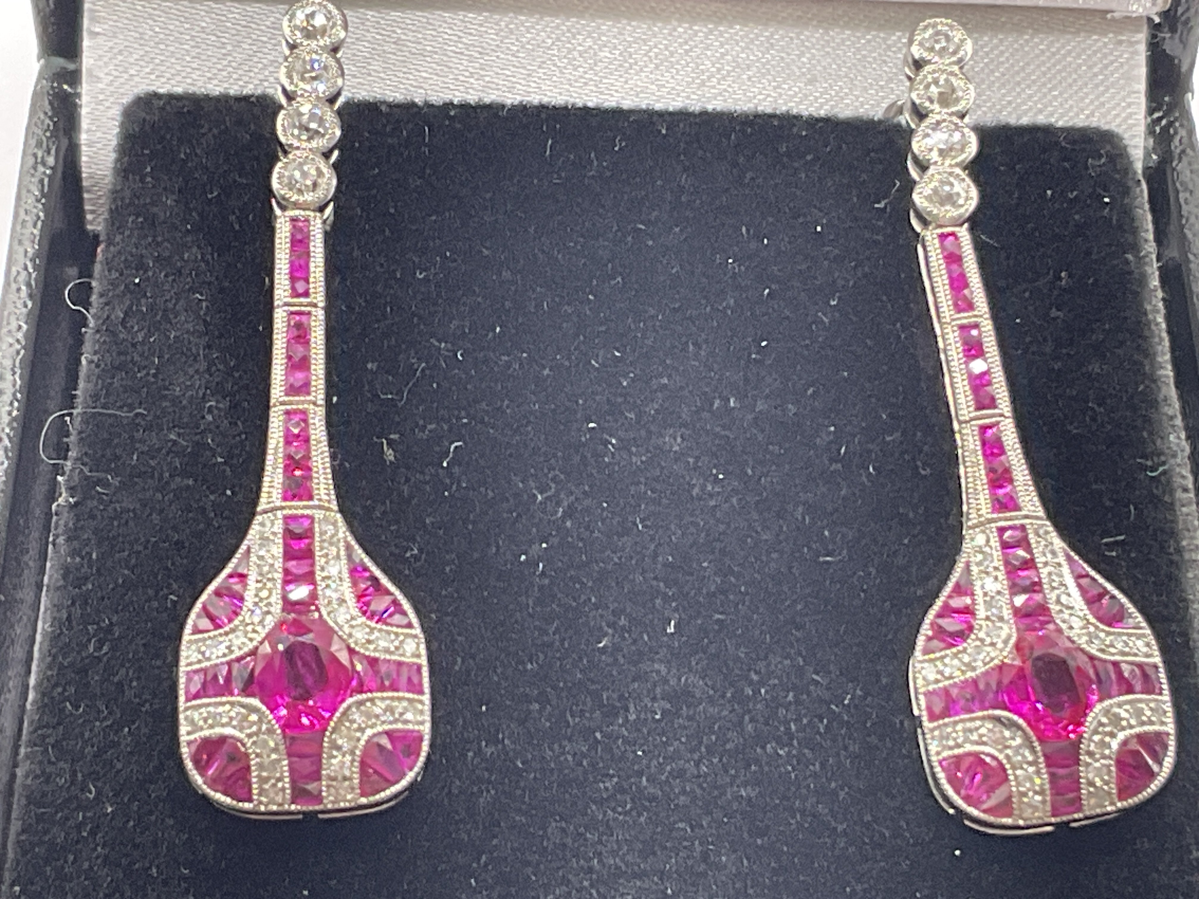 Pair of platinum ruby and diamond drop long drop dress earrings, boxed. Centre oval cut rubies 1.00ct. RBC and R/C diamonds 0.61ct. Remaining rubies 1.50ct. Postage category A.