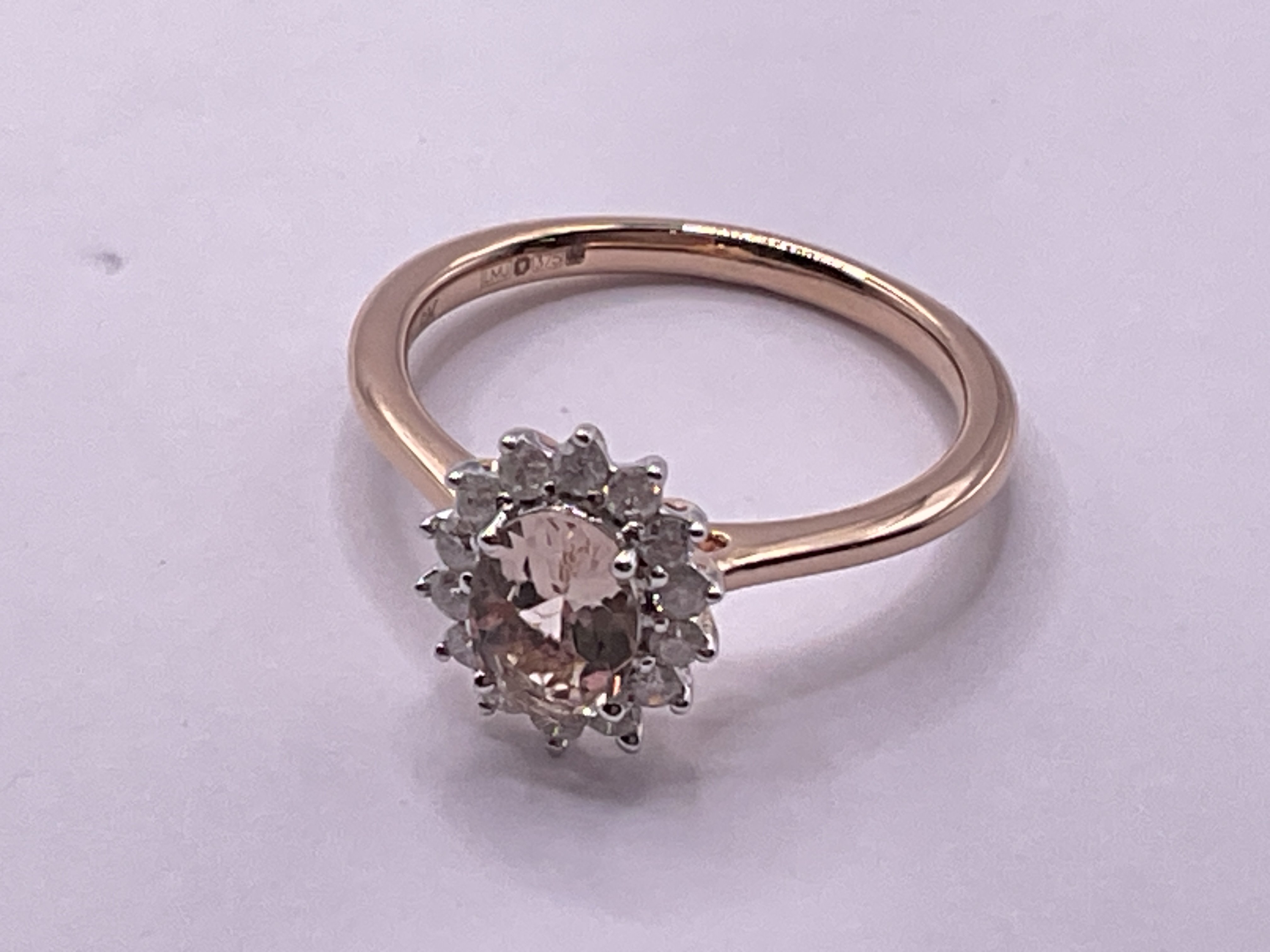 9ct rose gold cluster ring set with a central oval cut morganite and surrounding diamonds. Morganite 0.80ct. Diamonds 0.25ct. Ring size approx N. Postage category A.