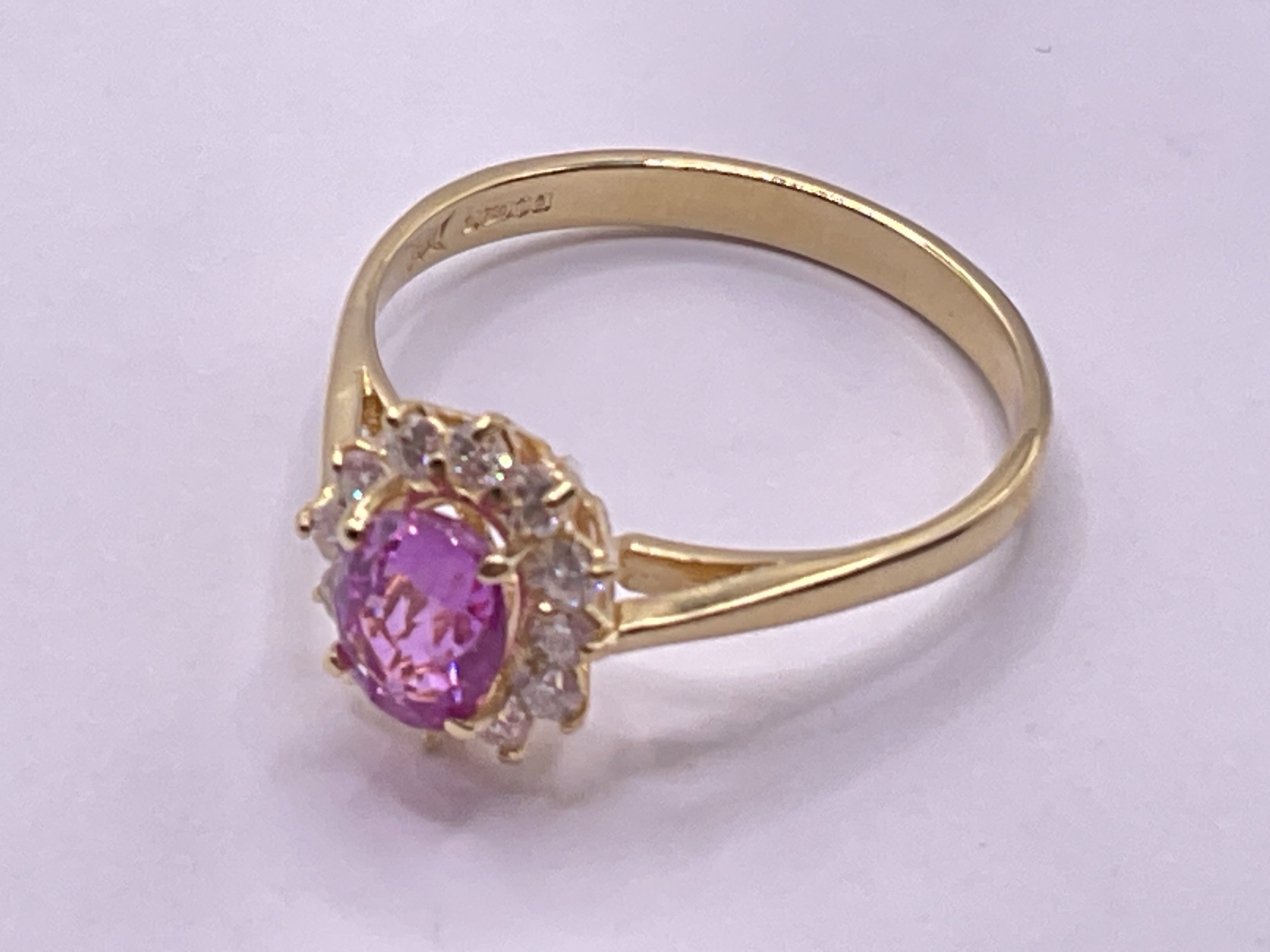 18ct yellow gold oval pink sapphire and RBC diamond cluster ring. Pink sapphire 0.65ct approx. Diamonds 0.50ct approx. Ring size approx R. Postage category A.