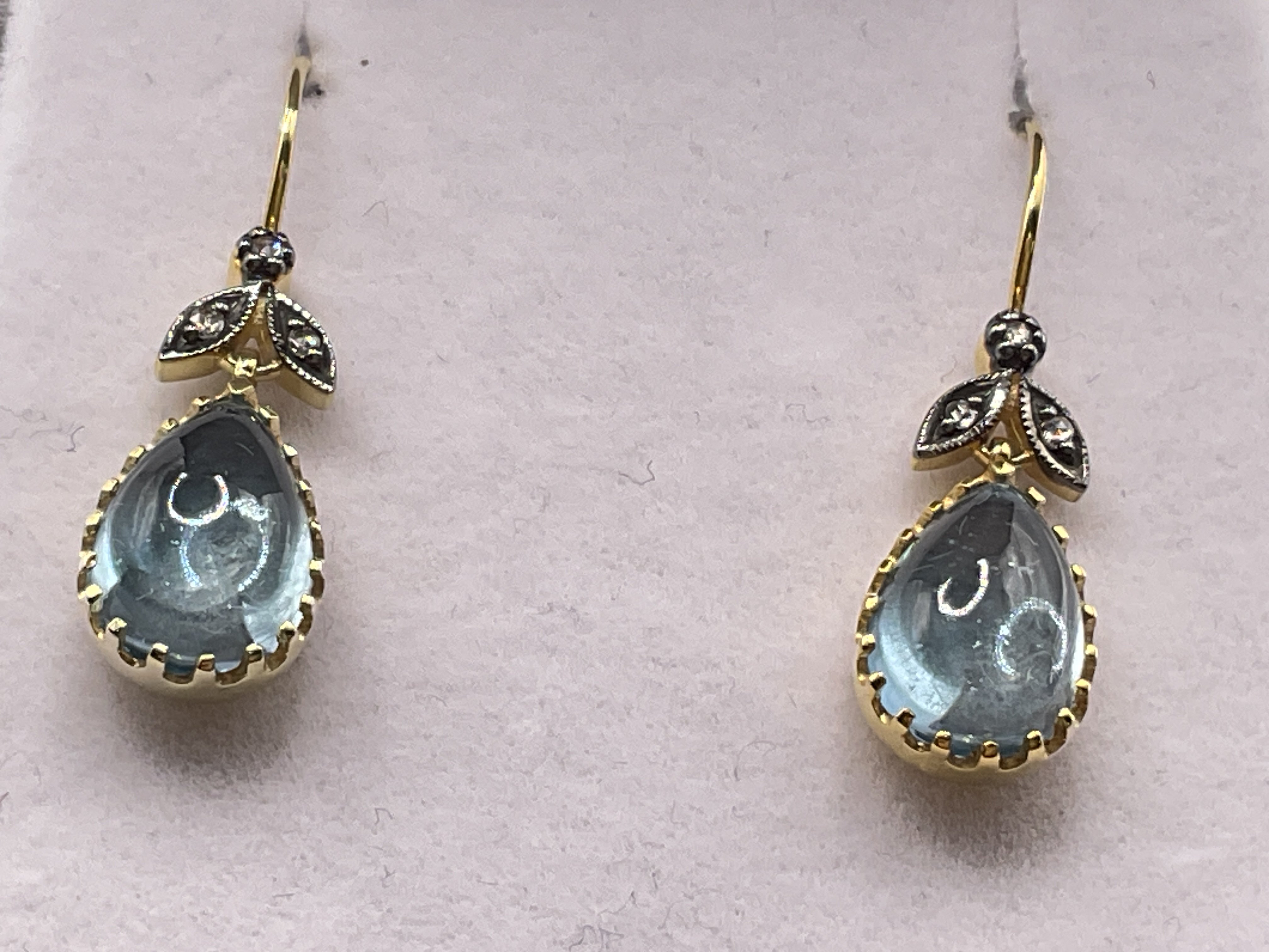 Pair of 9ct yellow gold and silver drop earrings set with a pair shaped cabochon topaz and rose cut diamond set bales, boxed. Topaz 2.80ct. Diamonds 0.06ct. Postage category A.