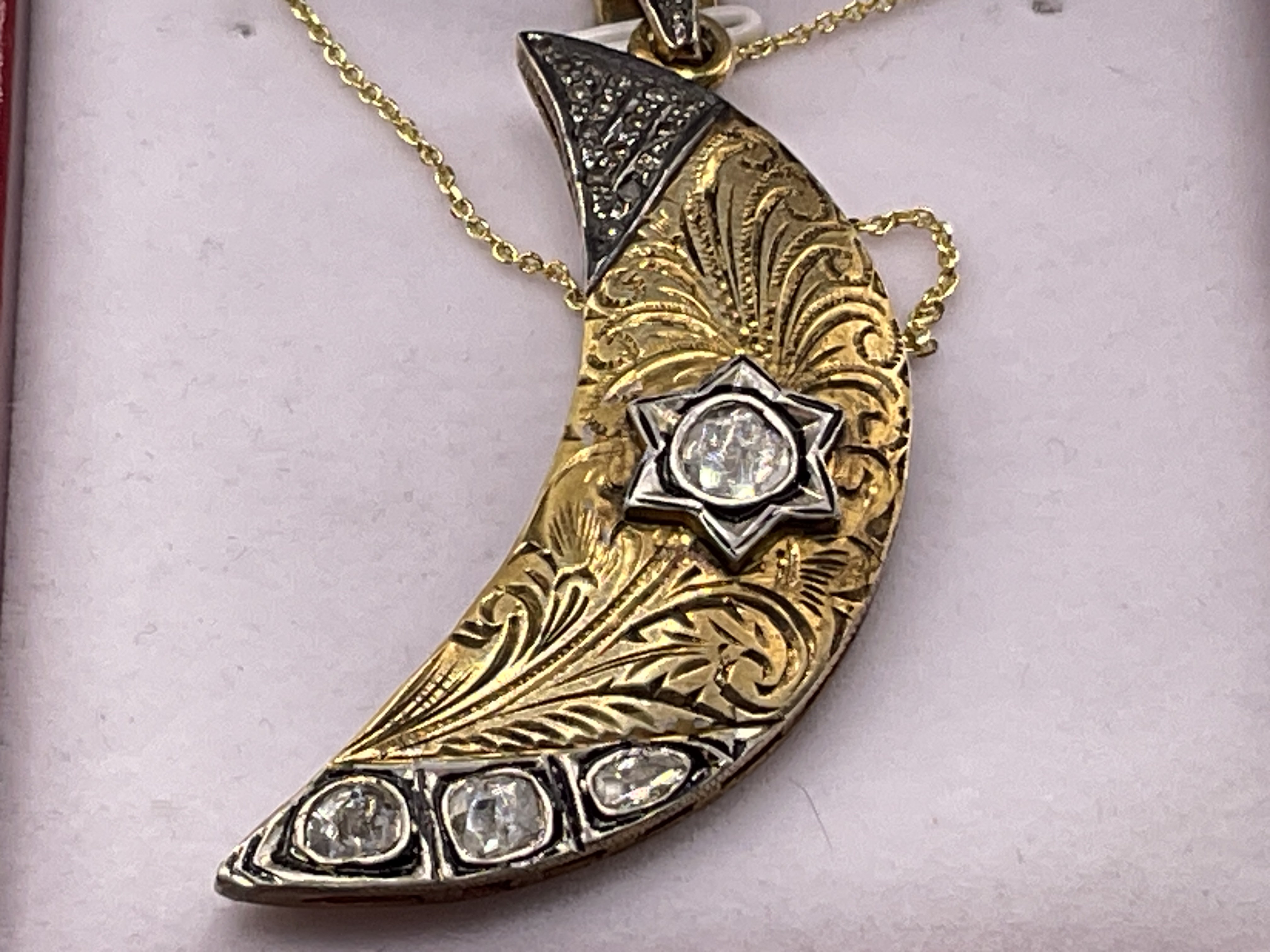 Unusual silver gilt crescent moon shaped pendant set with slice diamonds and mixed cut diamonds on a gold plated silver chain, boxed. Diamonds 0.83ct. Postage category A.