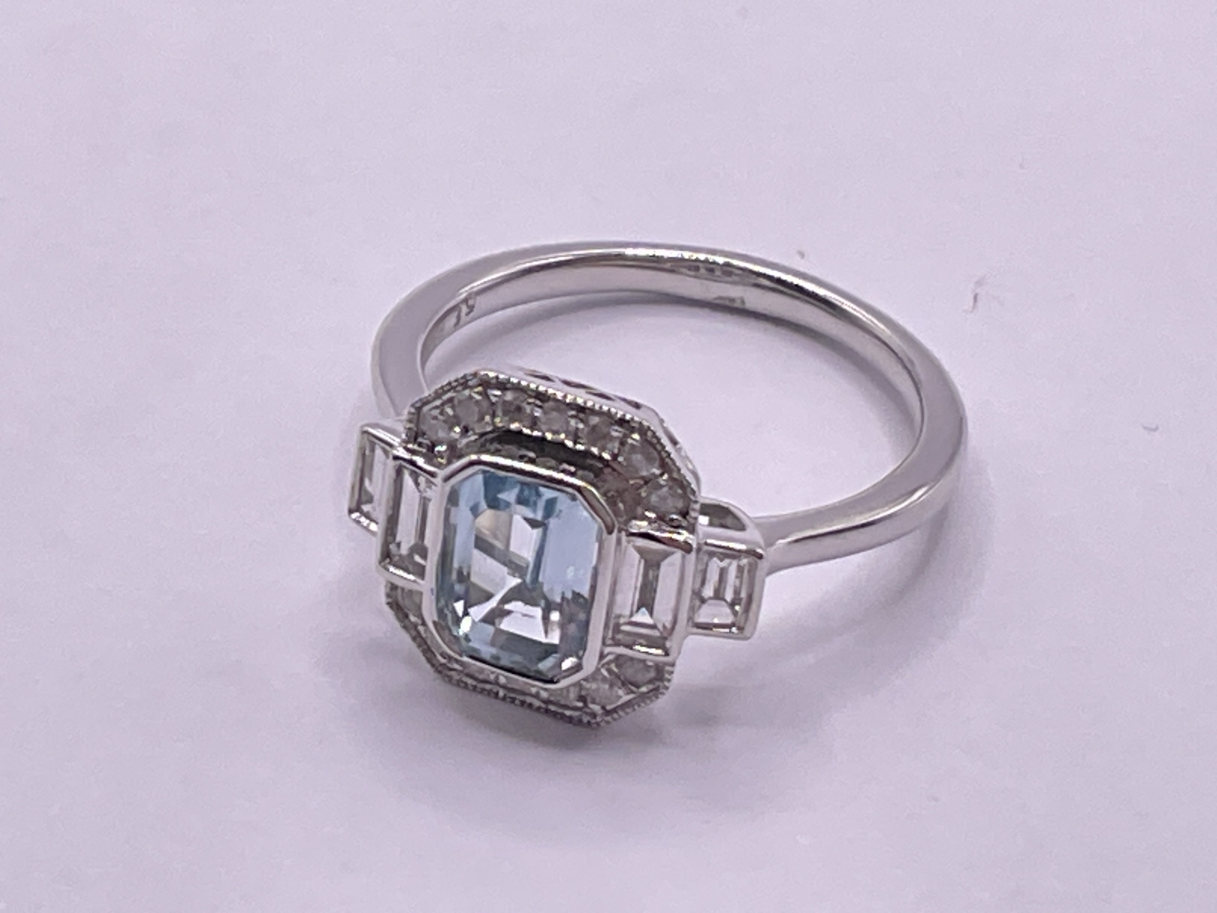 9ct white gold step cut Swiss blue topaz, RBC and baguette cut diamond Art Deco style dress ring. Topaz 1.03ct, diamonds 0.46ct. Ring size approx K/L. Postage category A.