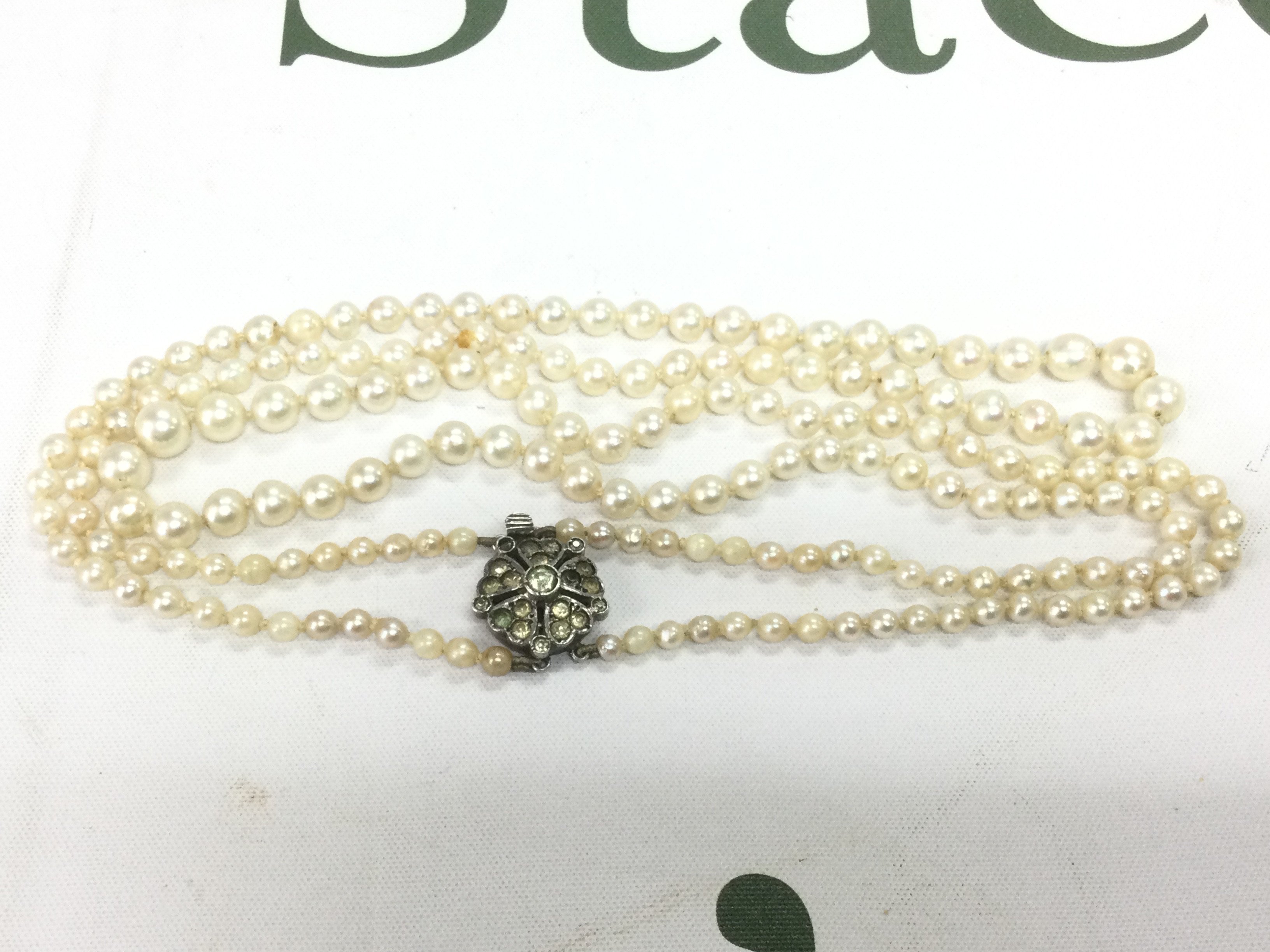 A pearl necklace with a silver clasp. Shipping category A.