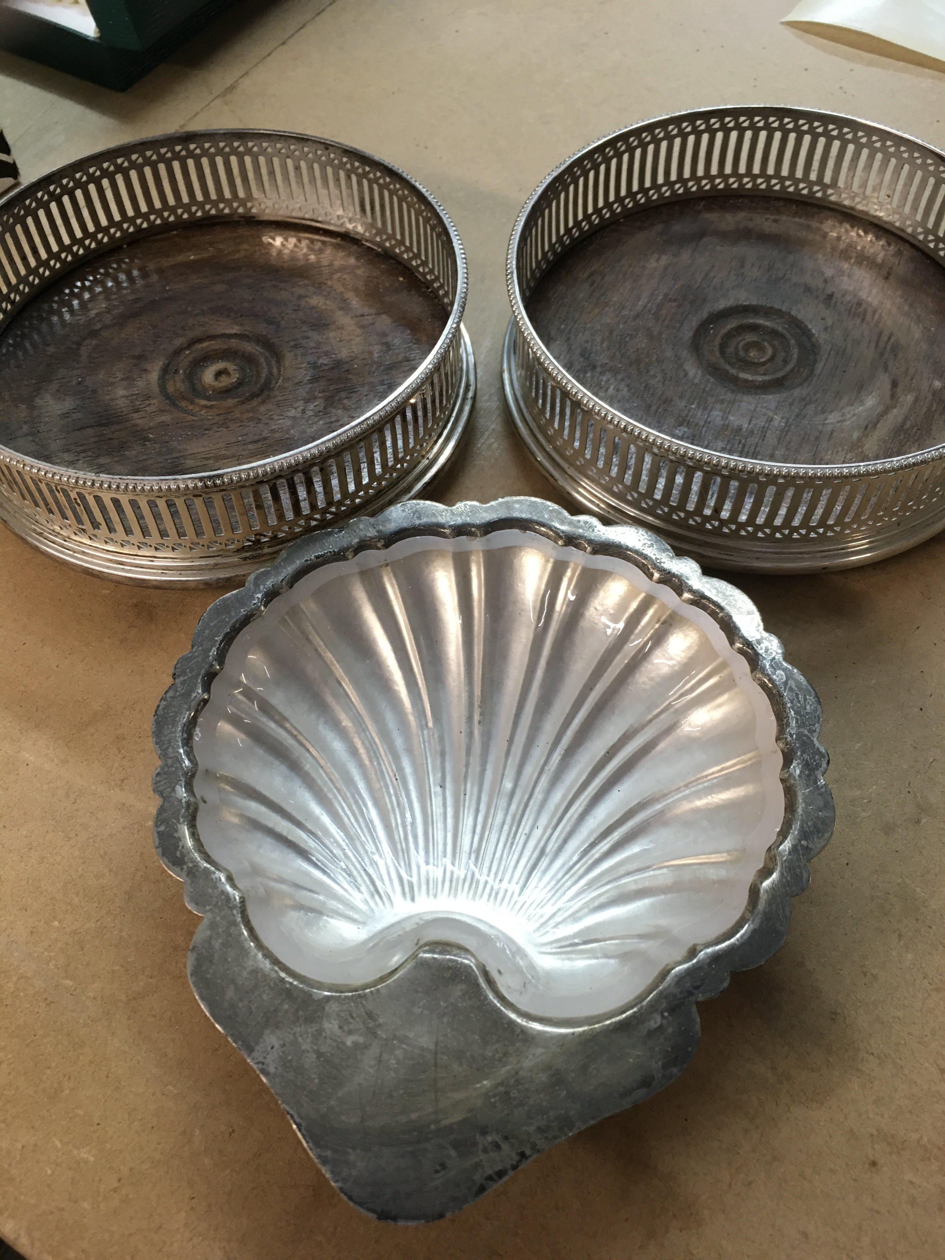 A pair of wine coasters and a silver butter dish .